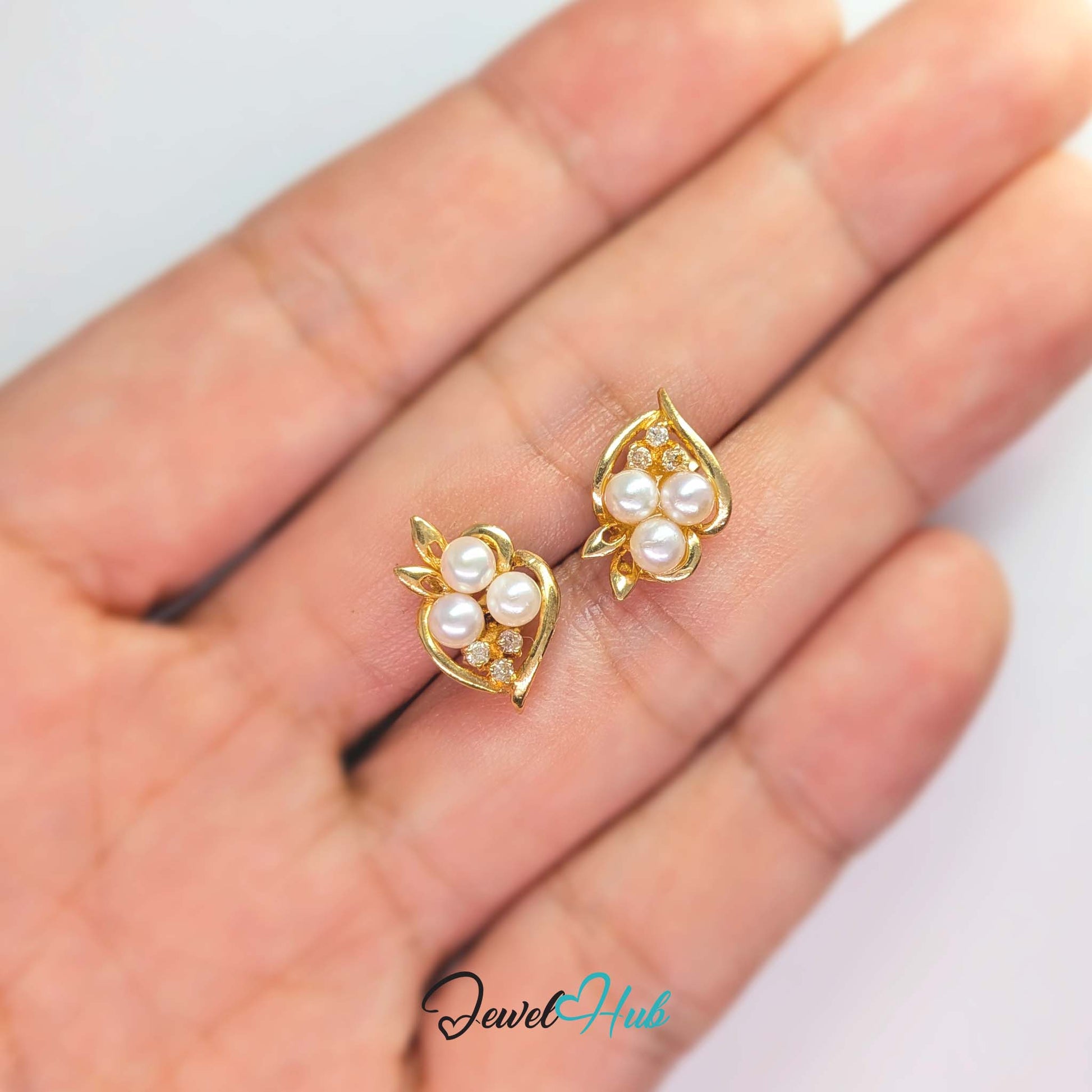 Three small round diamonds claw-set in the crook below the pearl cluster - JewelHub