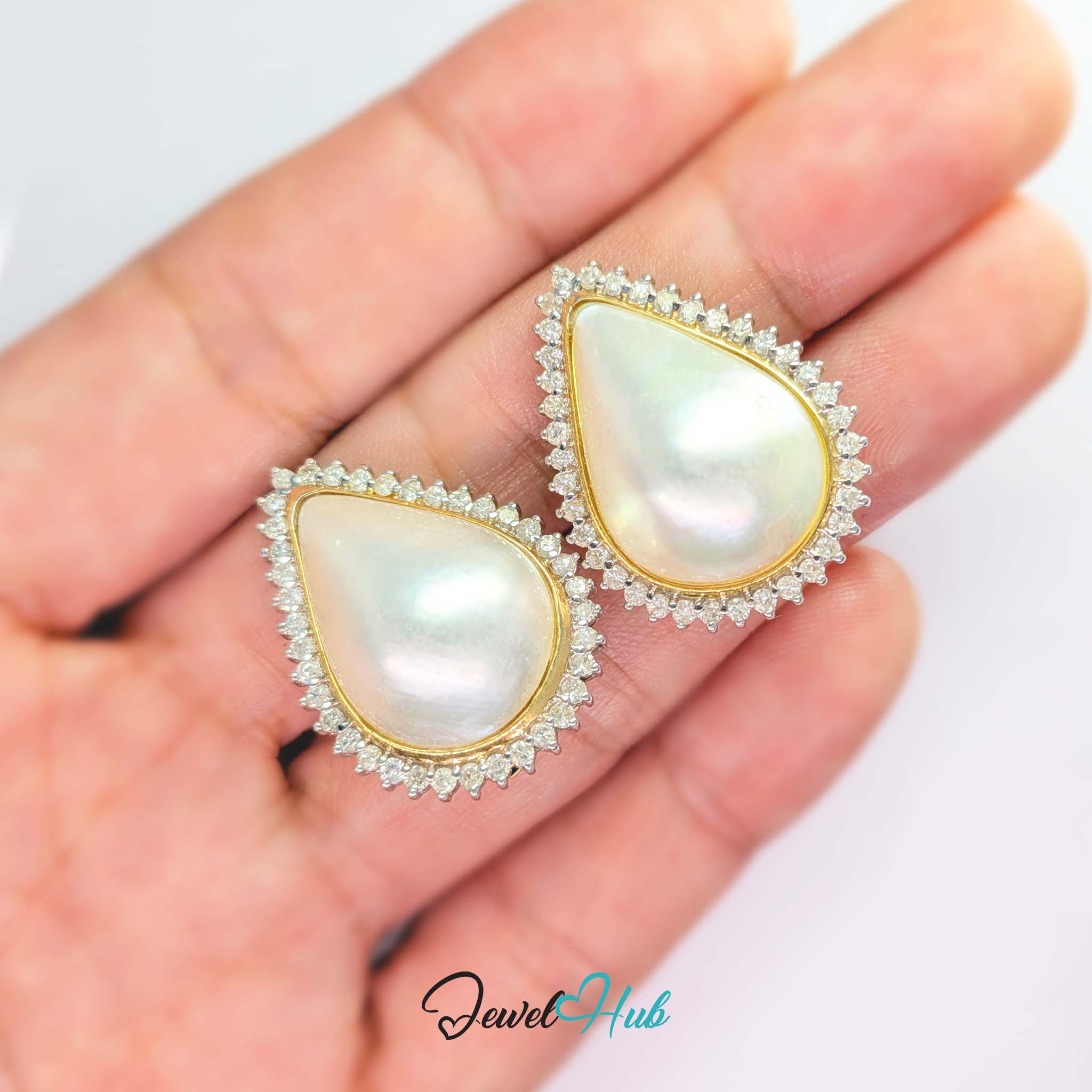 Seventy-six round diamonds ringing the pair, graduated larger at the point of the teardrop - JewelHub