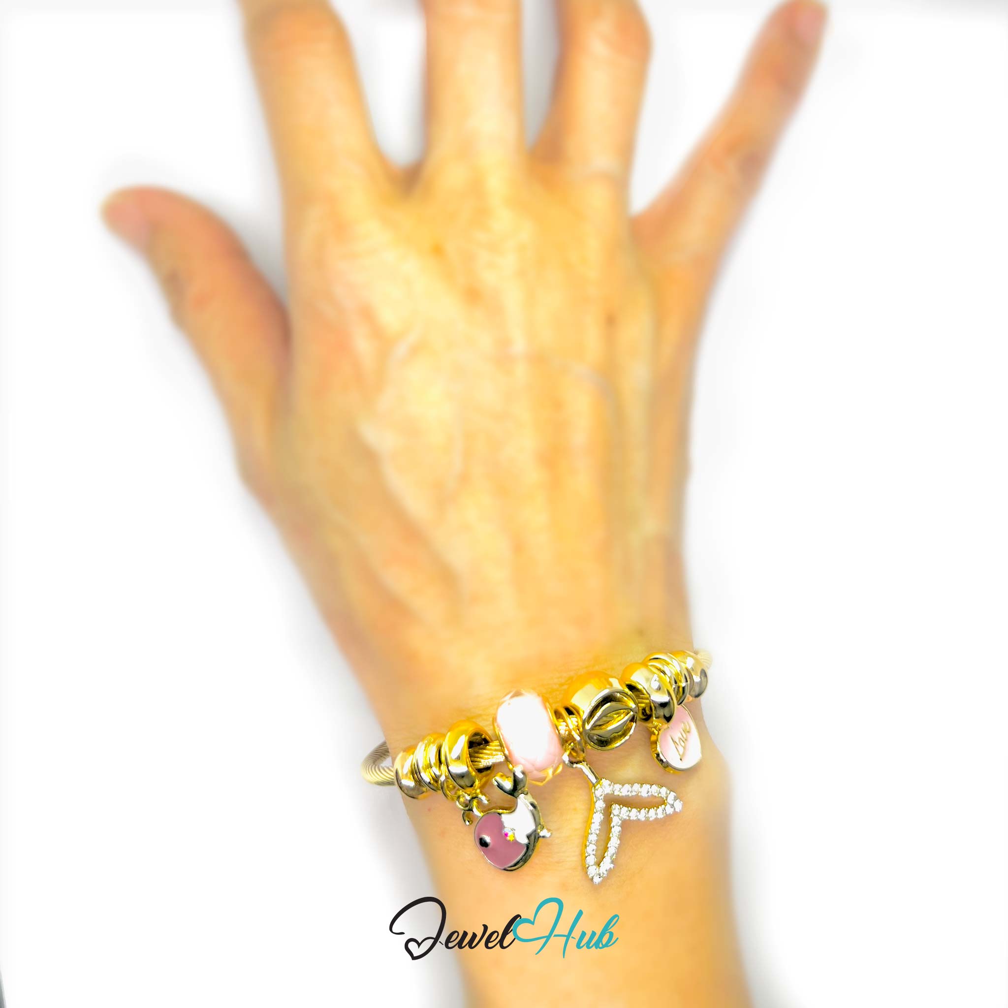 Hand wearing a gold bracelet with charms on a white background, branded 'Jewel Hub'.