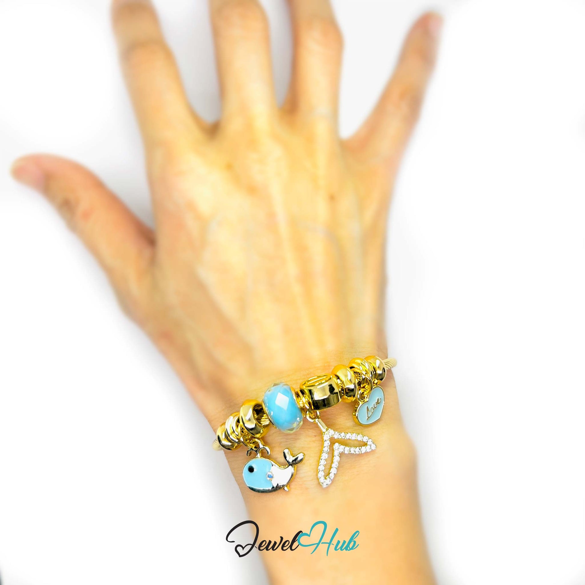 Hand wearing a gold and turquoise beaded bracelet on a white background with 'Jewel Hub' branding.