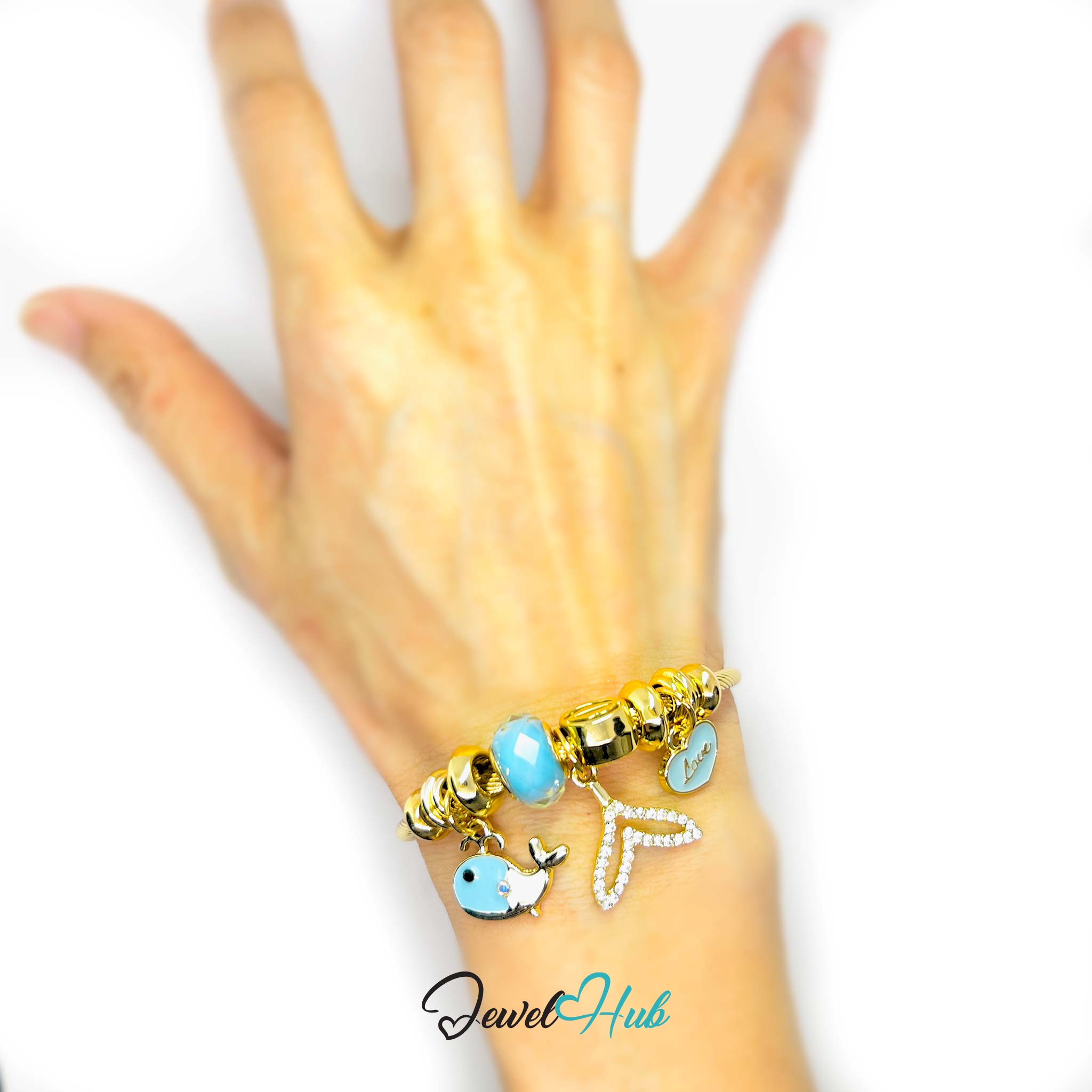 Hand wearing a gold and turquoise beaded bracelet on a white background with 'Jewel Hub' branding.