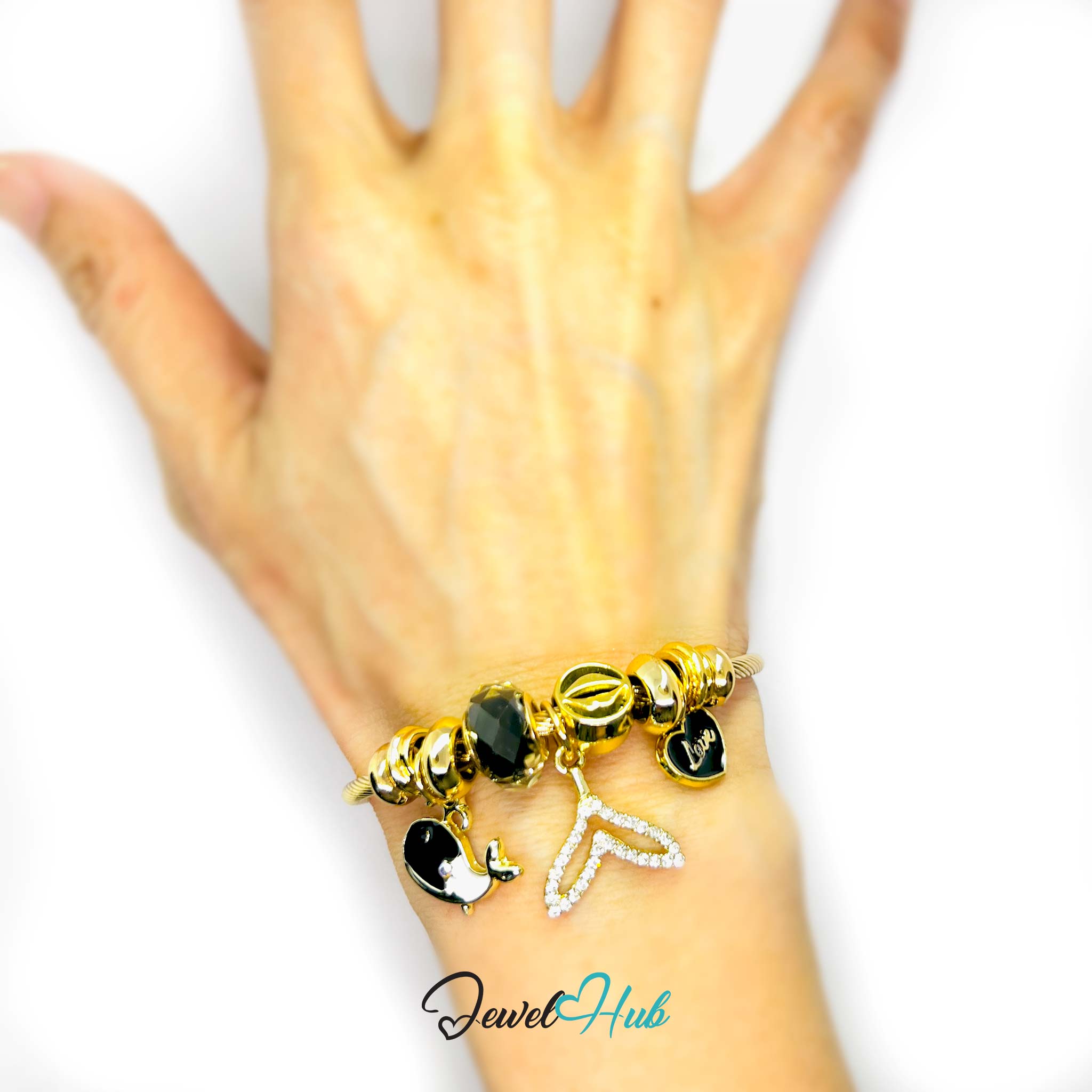 Gold bracelet with black charms on a hand against a white background, branded 'Jewel Hub'.