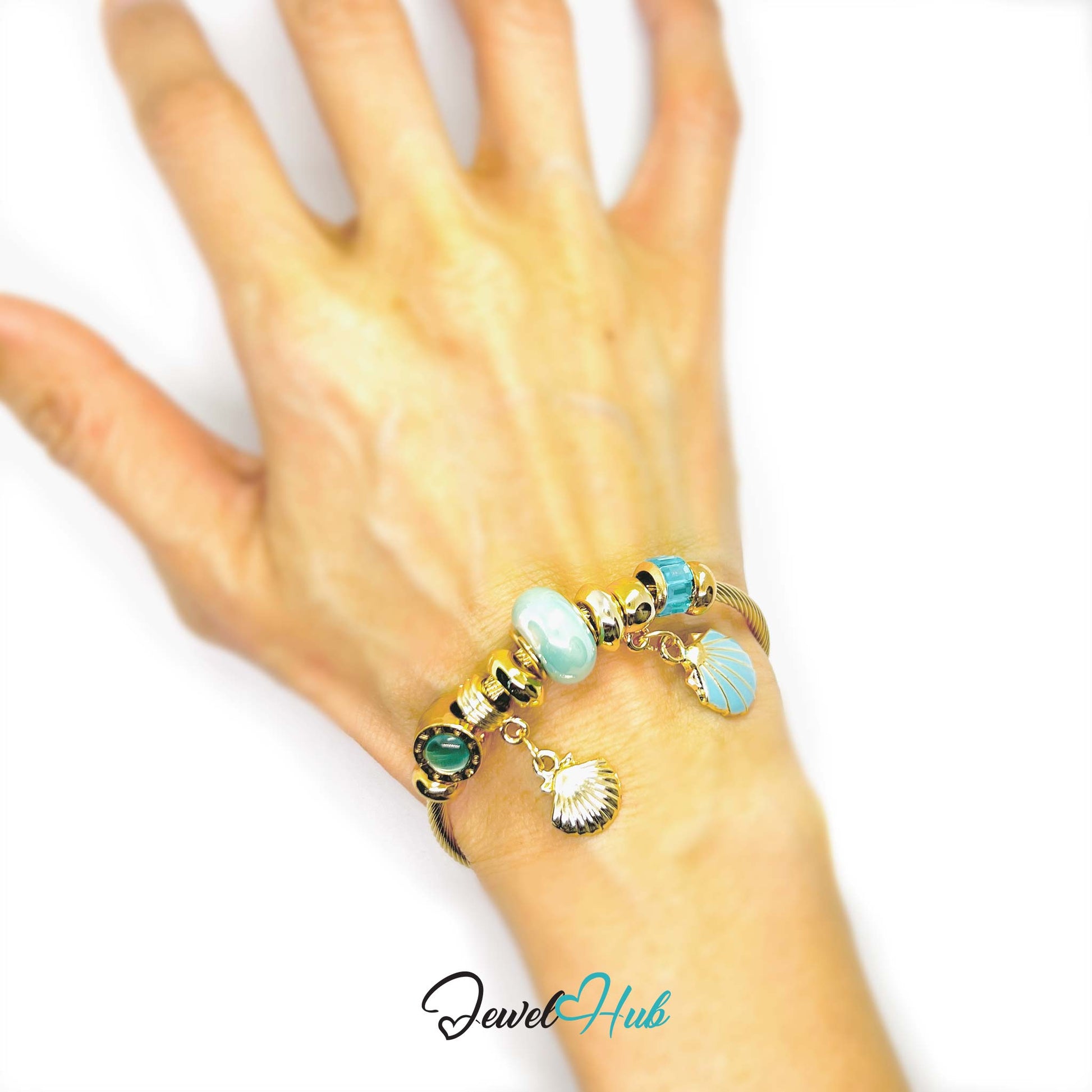 Hand wearing a bracelet with turquoise and gold beads on a white background, branded 'Jewel Hub'.