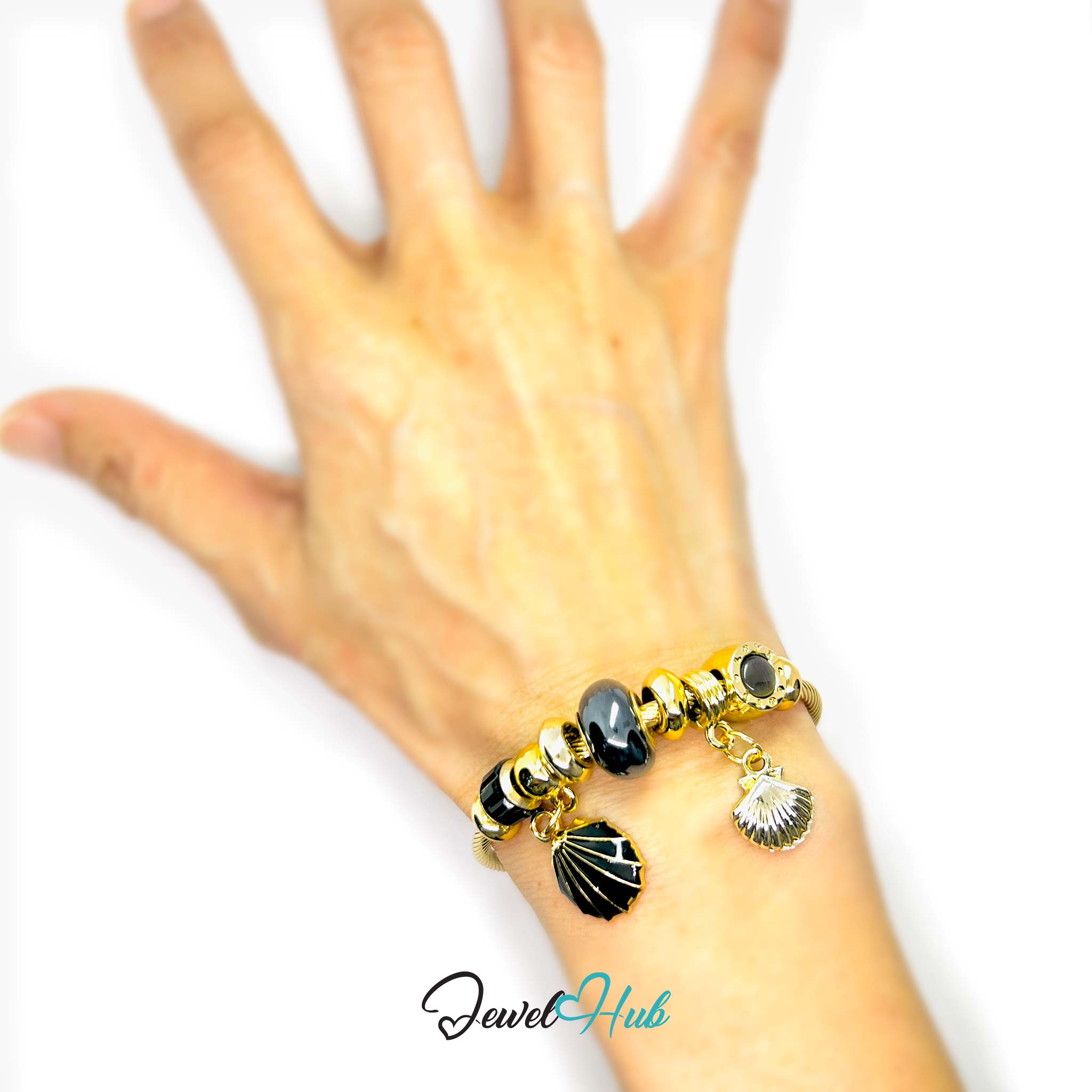 Hand wearing a bracelet with black and gold beads on a white background, branded 'Jewel Hub'.