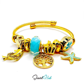 Gold bracelet with various charms including a blue heart, starfish, and tree of life on a white background.