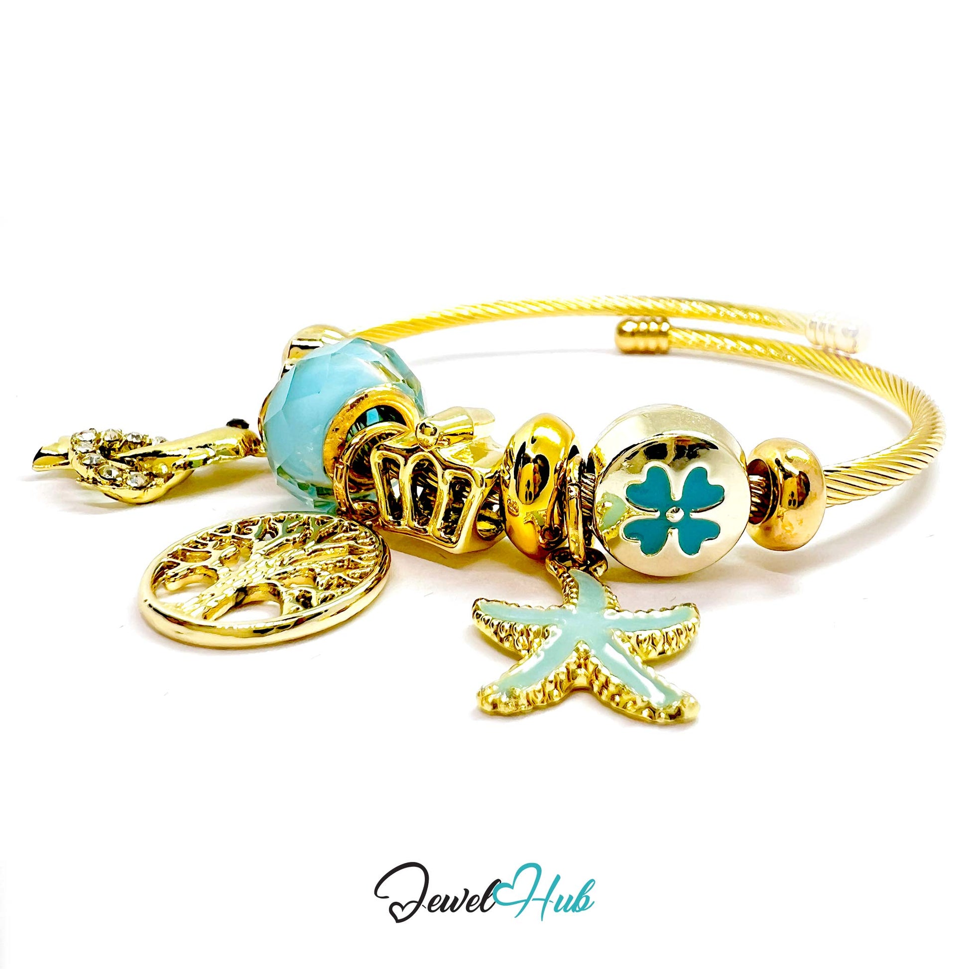 Gold bracelet with charms including a starfish, tree, and circular design on a white background.
