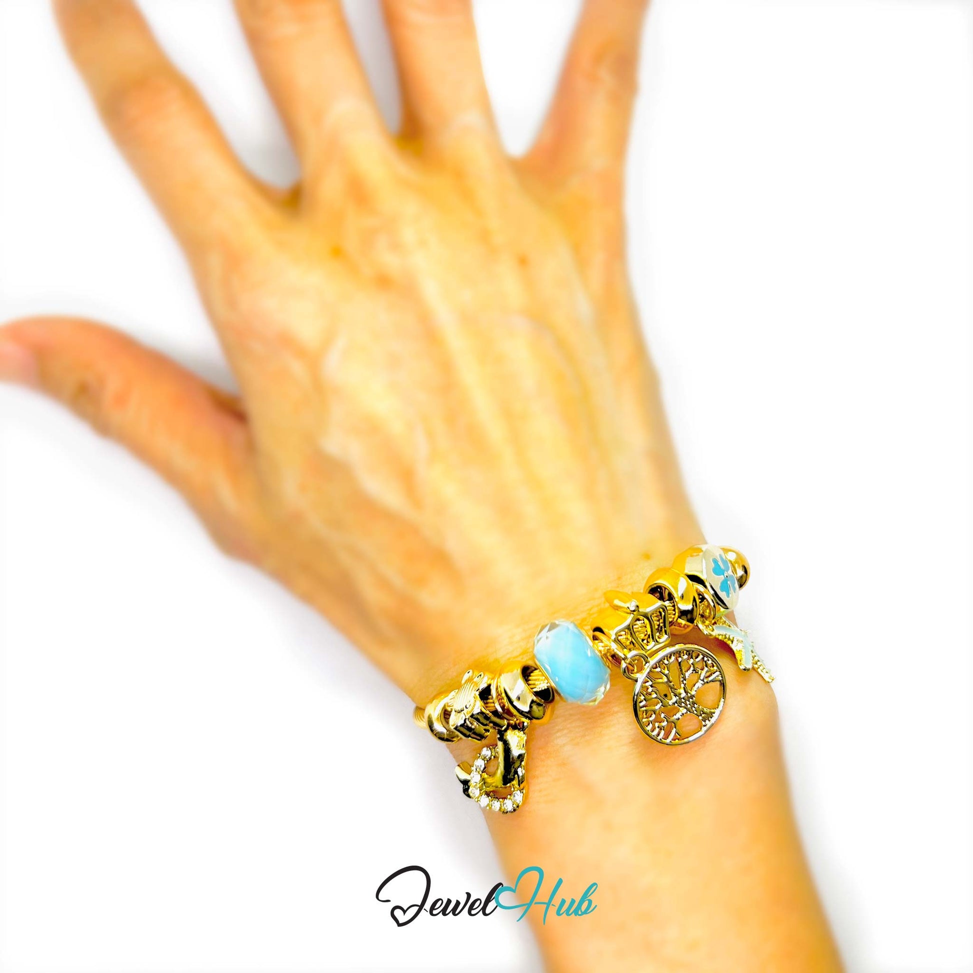 Gold bracelet with turquoise charm on a wrist against a white background, branded 'Jewel Hub'.