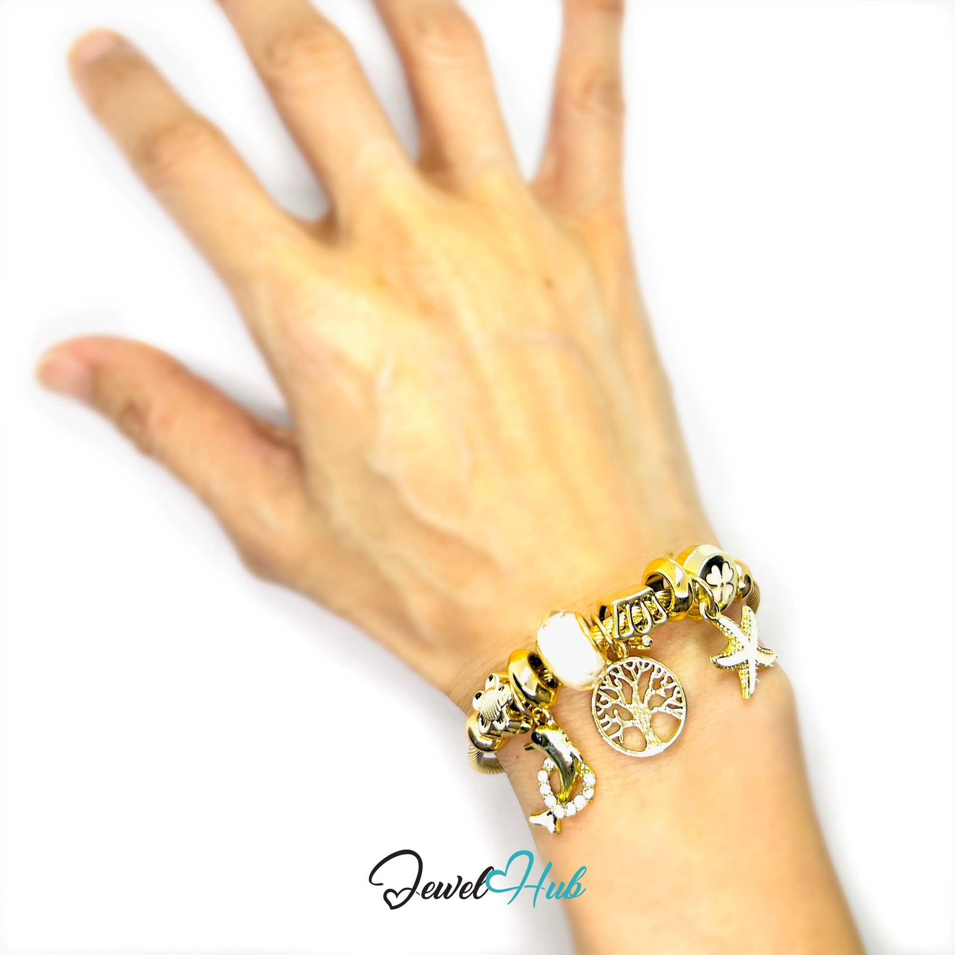 Gold bracelet with charms on a hand against a white background, brand 'Jewel Hub' visible.