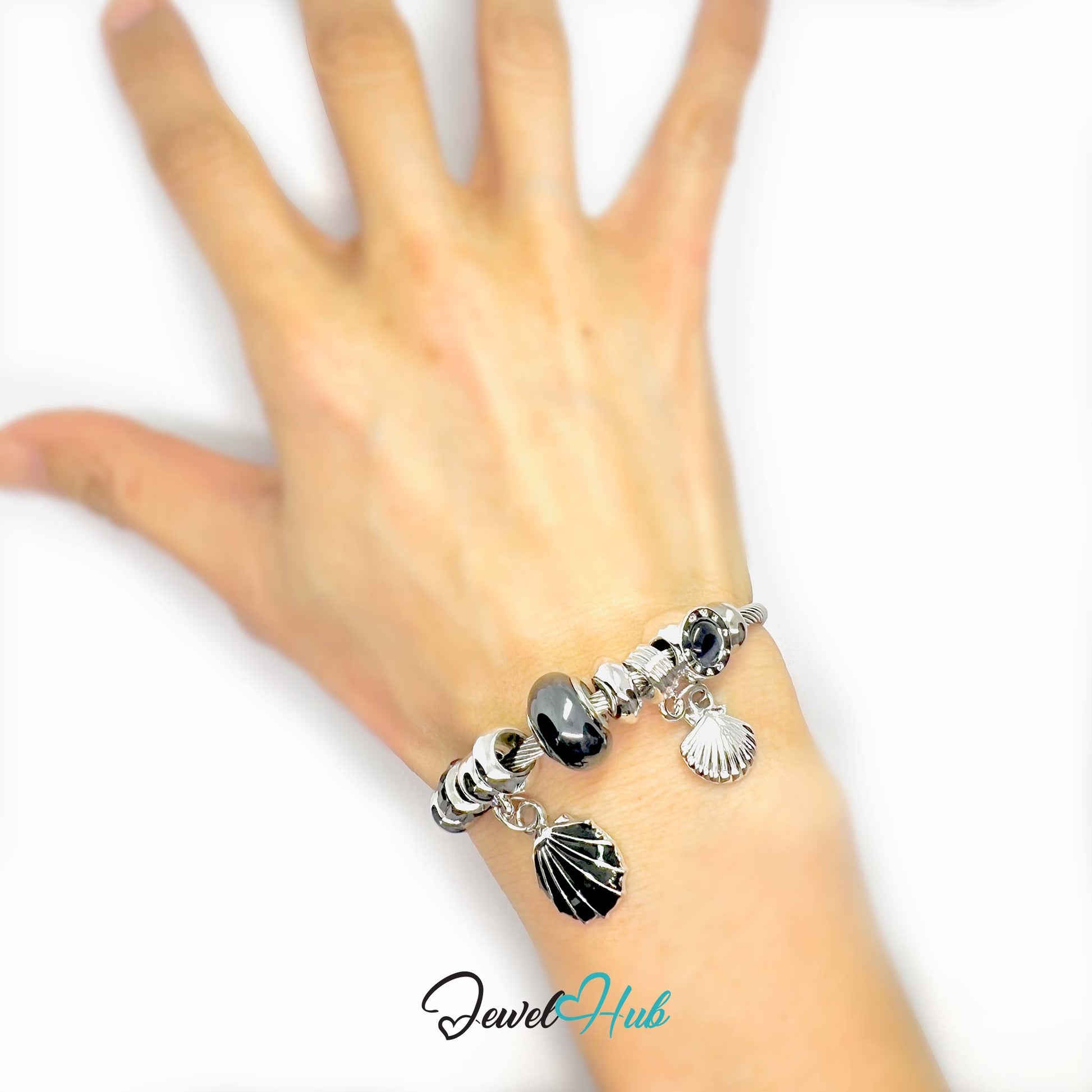 Bracelet with shell charms on a wrist against a white background, branded 'Jewel Hub'.