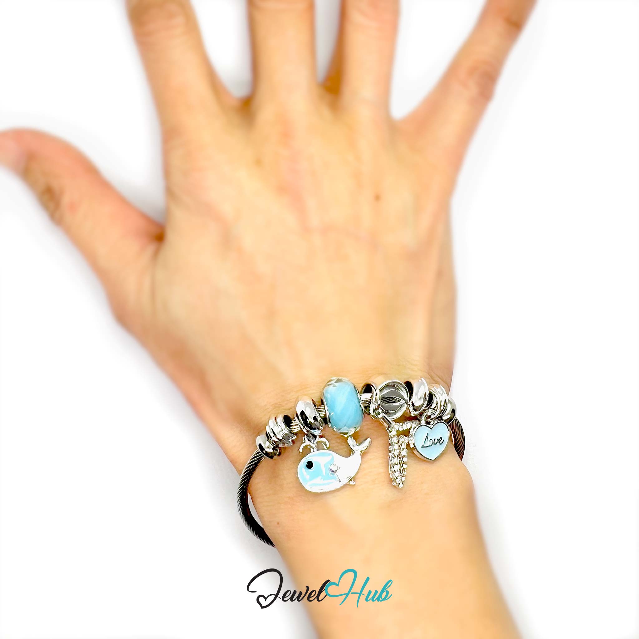 Hand wearing a bracelet with charms on a white background, featuring the brand 'Jewel Hub'.