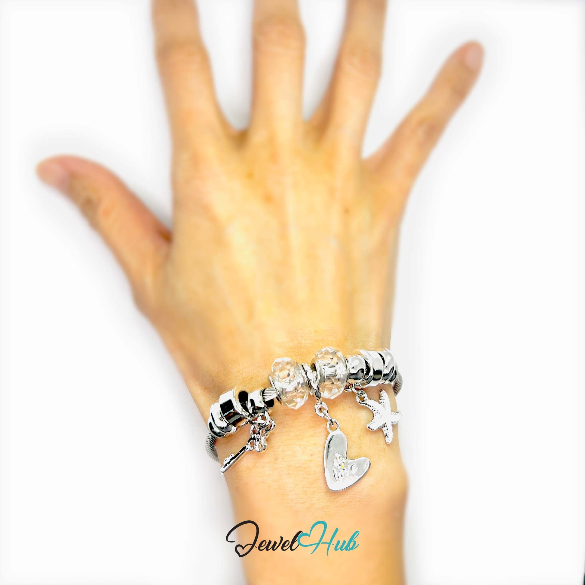 Silver charm bracelet on a wrist with 'Jewel Hub' branding.