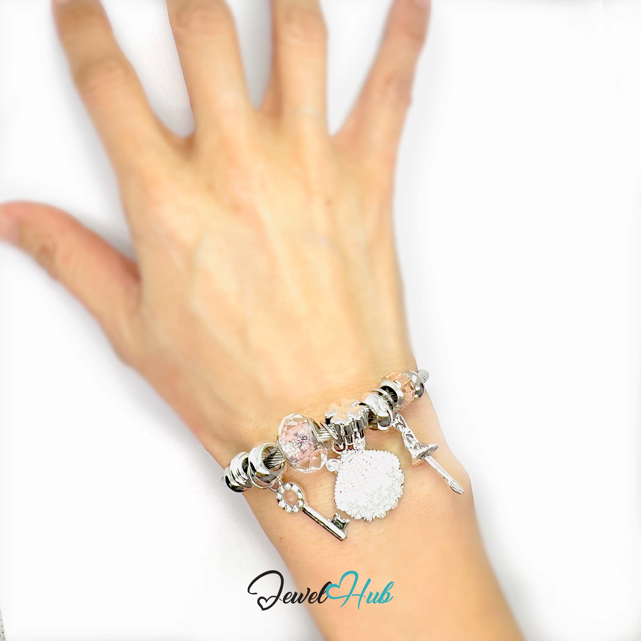 Silver bracelet with various charms on a white background