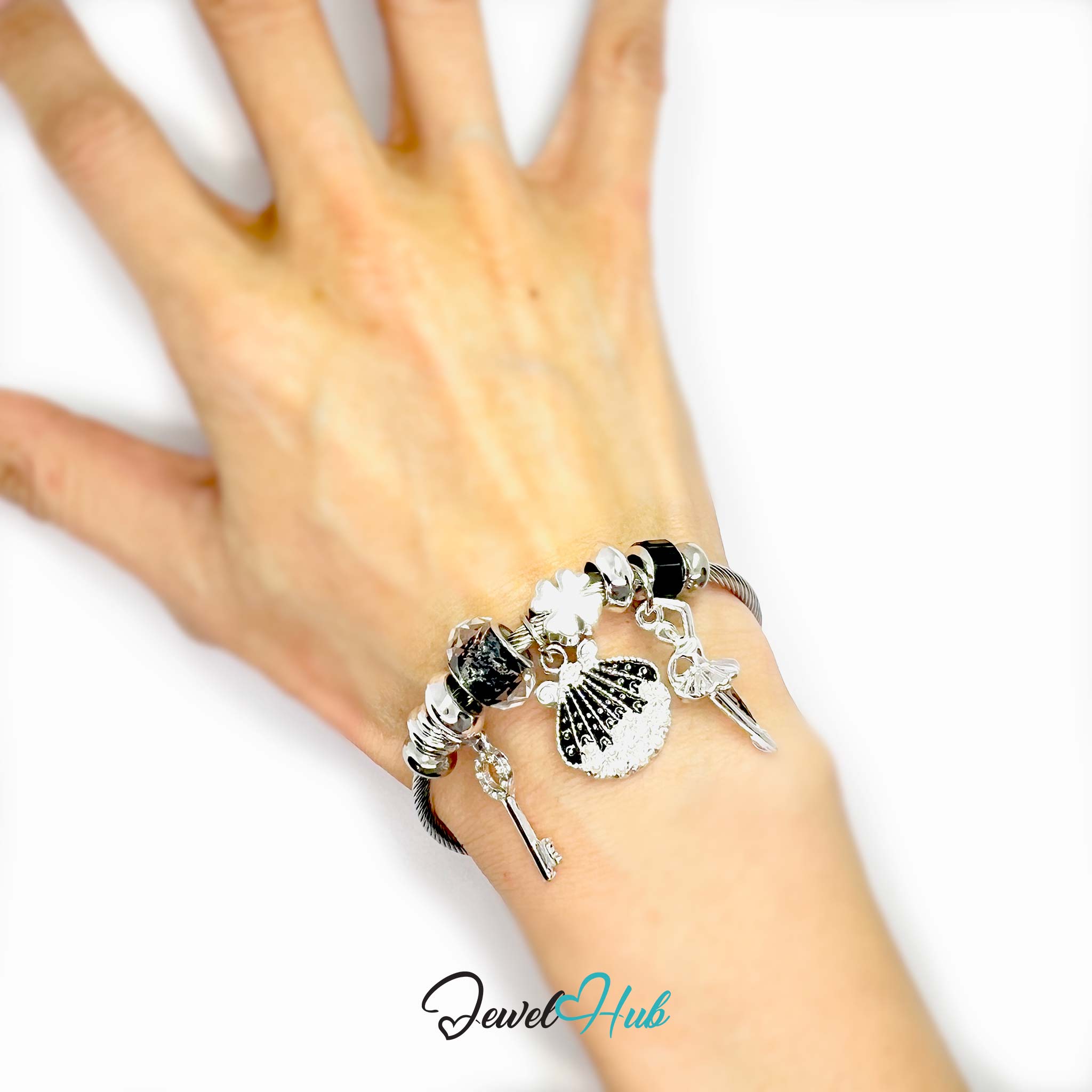 Hand wearing a bracelet with various charms on a white background, branded 'Jewel Hub'.