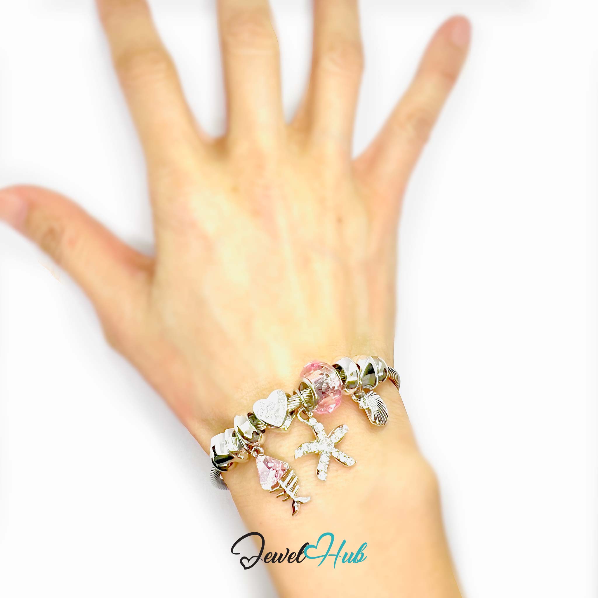 Hand wearing a bracelet with charms on a white background, branded 'Jewel Hub'.