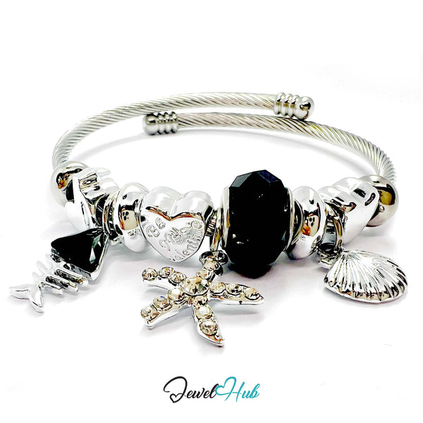 Silver bracelet with various charms including a starfish, heart, and shell on a white background.