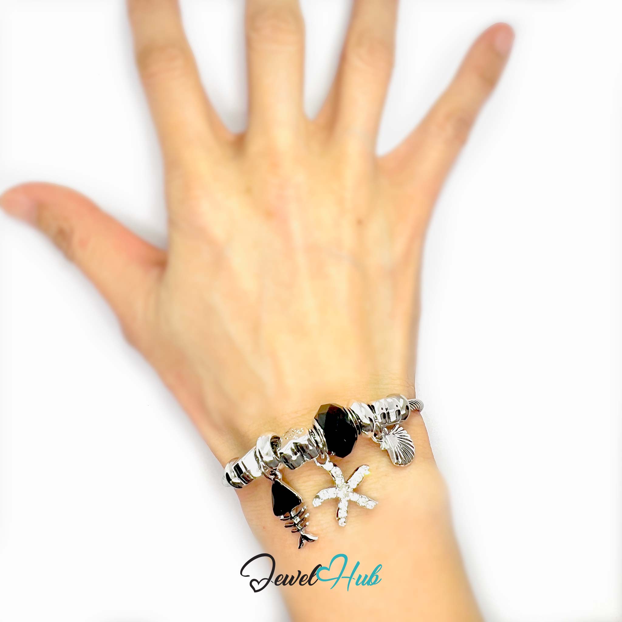 Silver stainless steel bracelet with various charms on a white background