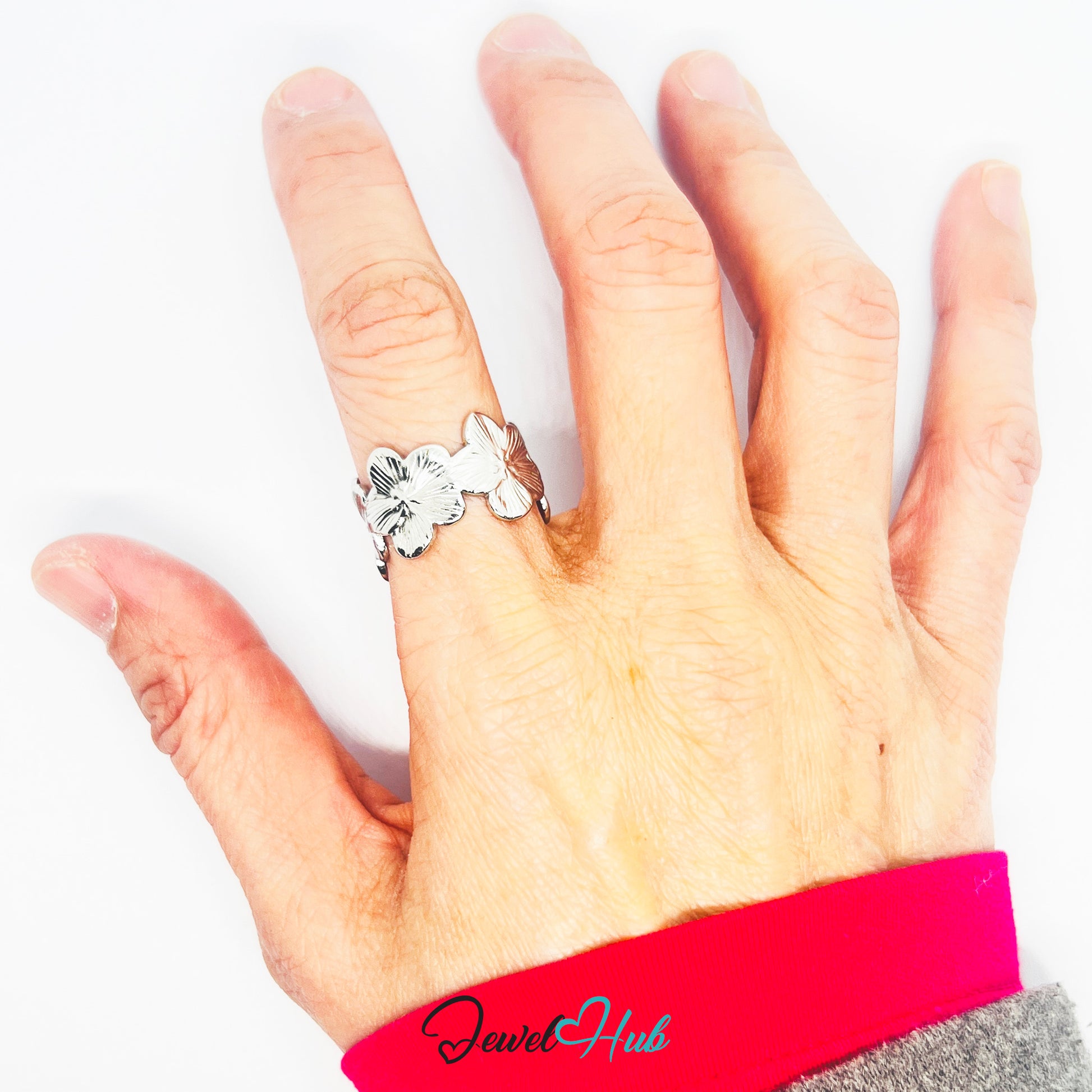 Hand wearing a silver ring with a white gemstone on a white background, featuring the brand 'Jewel Hub'.