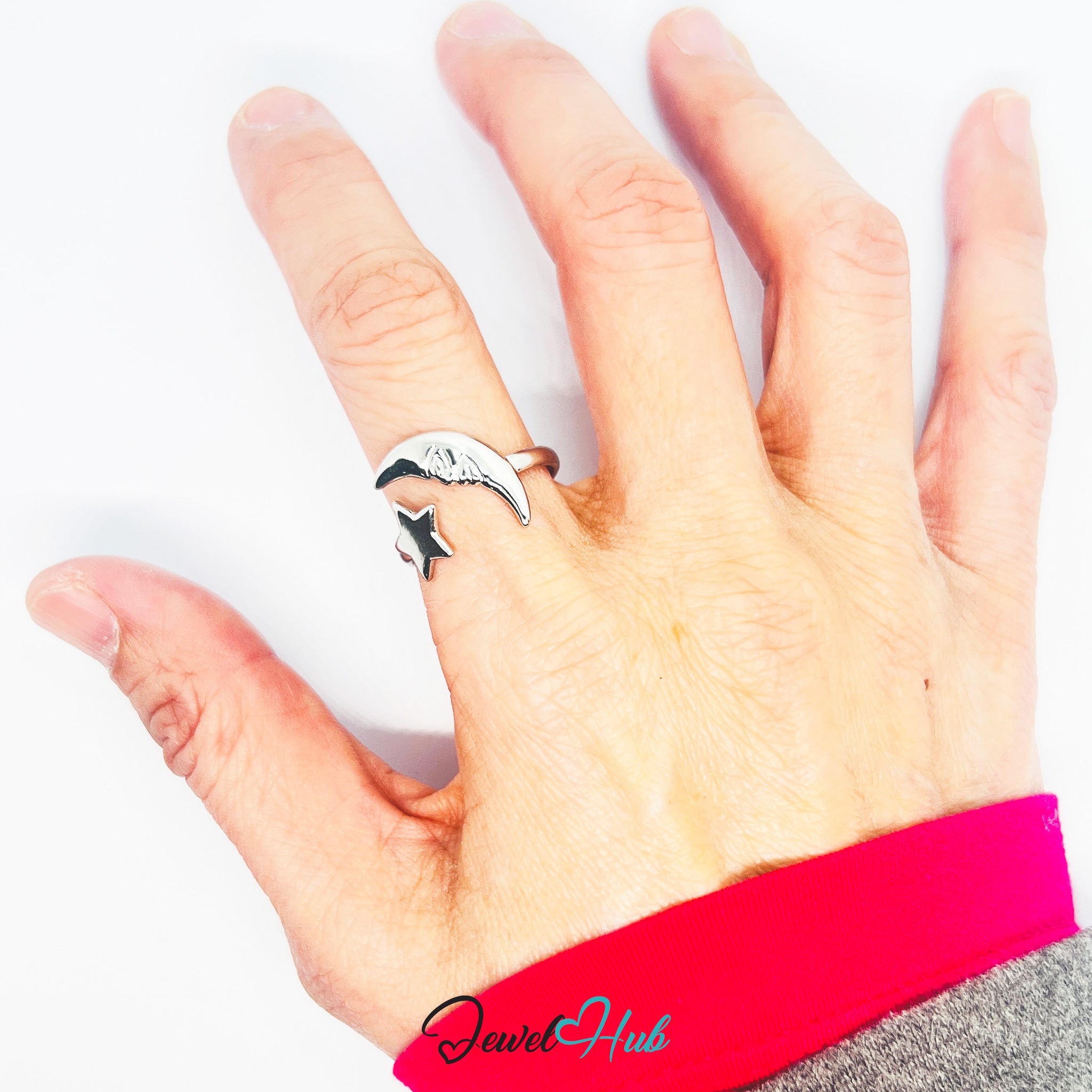 Hand wearing a silver ring with a star design on a white background