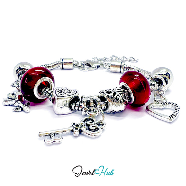 Silver bracelet with red heart charms on a white background, branded 'Jewel Hub'.