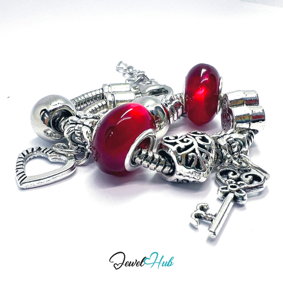 Silver charm bracelet with red beads on a white background, branded 'Jewel Hub'.