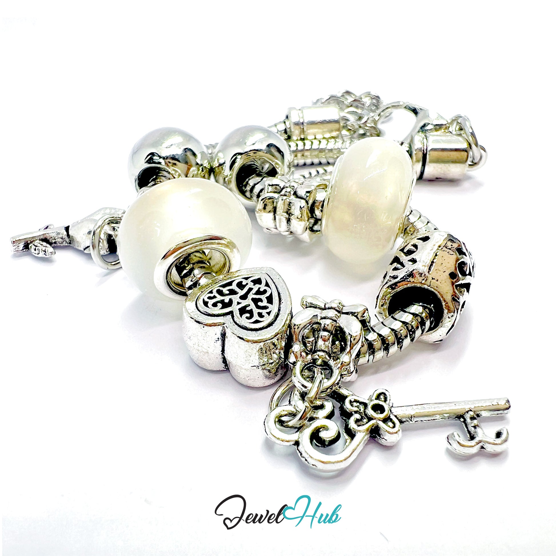 Silver bracelet with white beads and charms on a white background, branded 'Jewel Hub'.