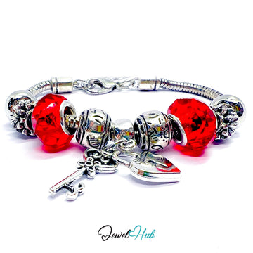 Silver bracelet with red beads and a key charm on a white background, branded 'Jewel Hub'.
