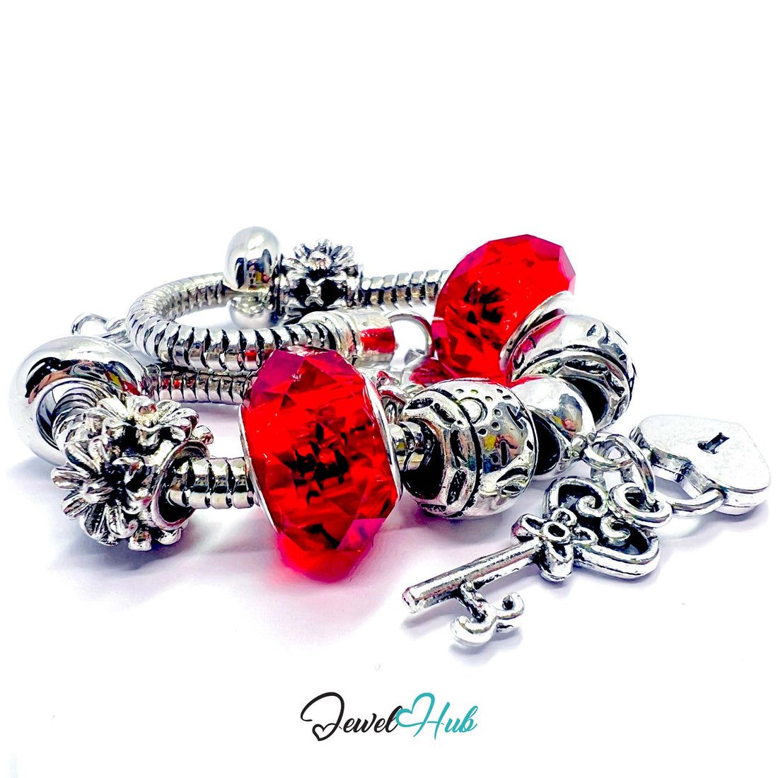 Silver bracelet with red beads and a key charm on a white background, branded 'Jewel Hub'.