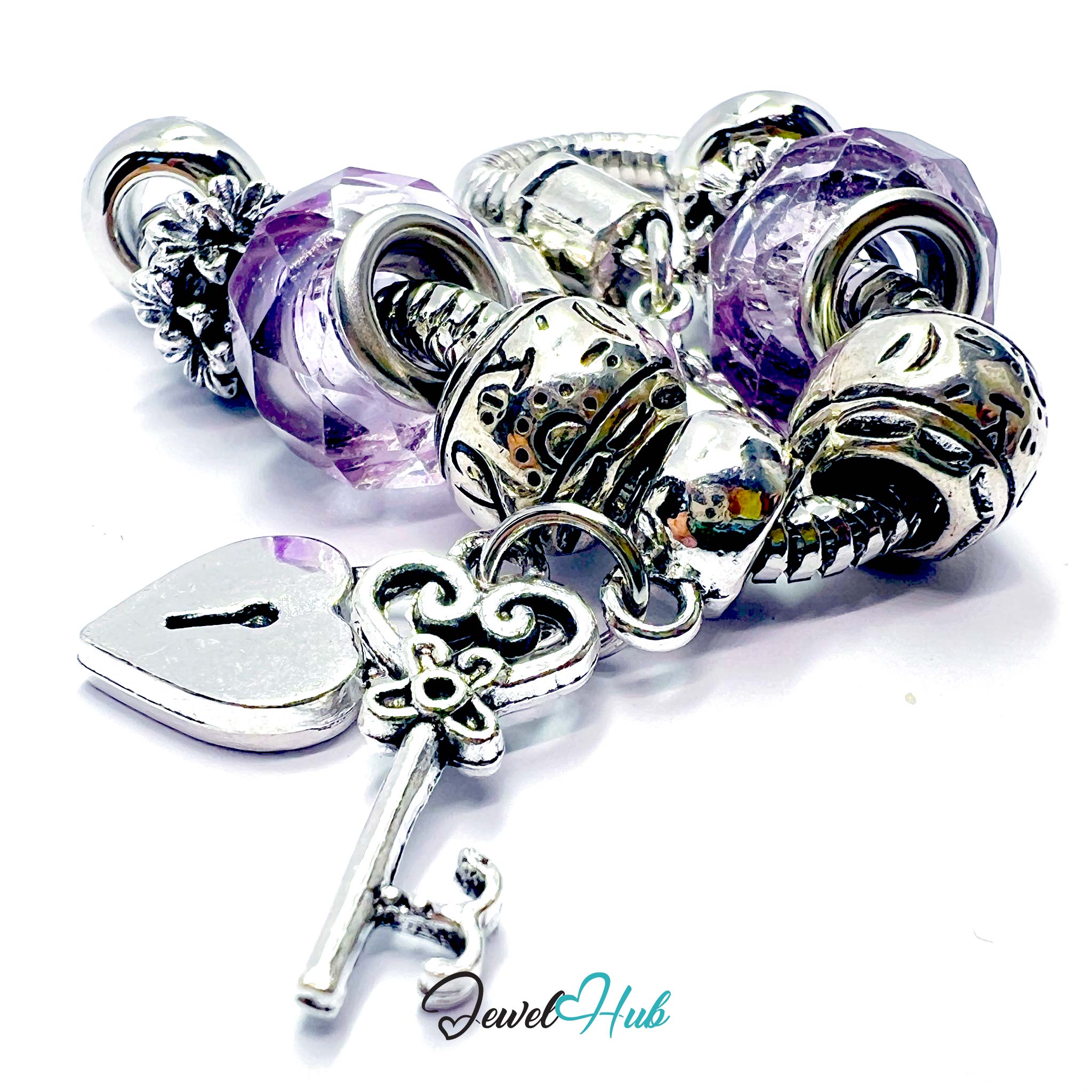 Silver bracelet with purple beads and decorative charms on a white background, branded 'Jewel Hub'.