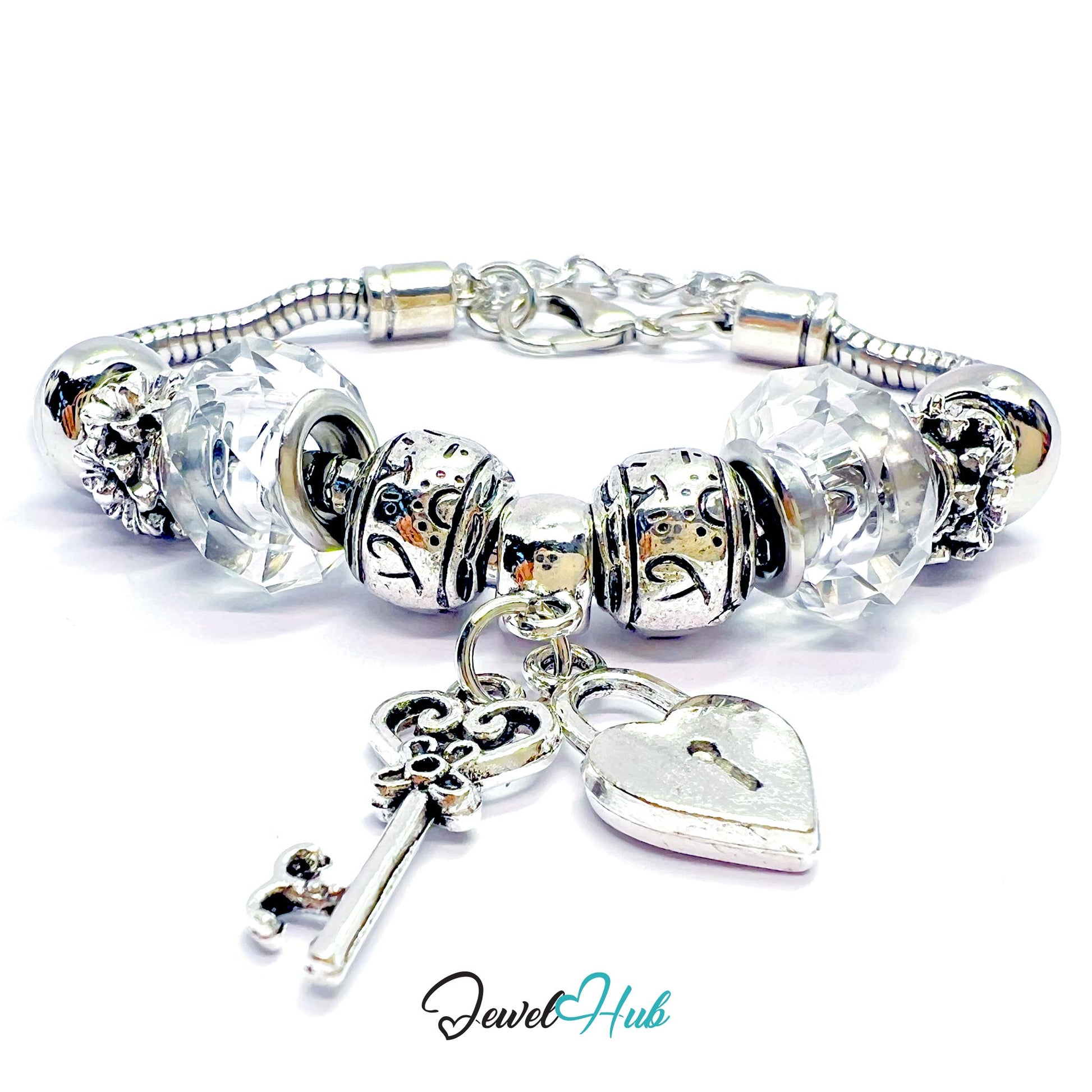 Silver charm bracelet with heart and key charms on a white background, branded 'Jewel Hub'.