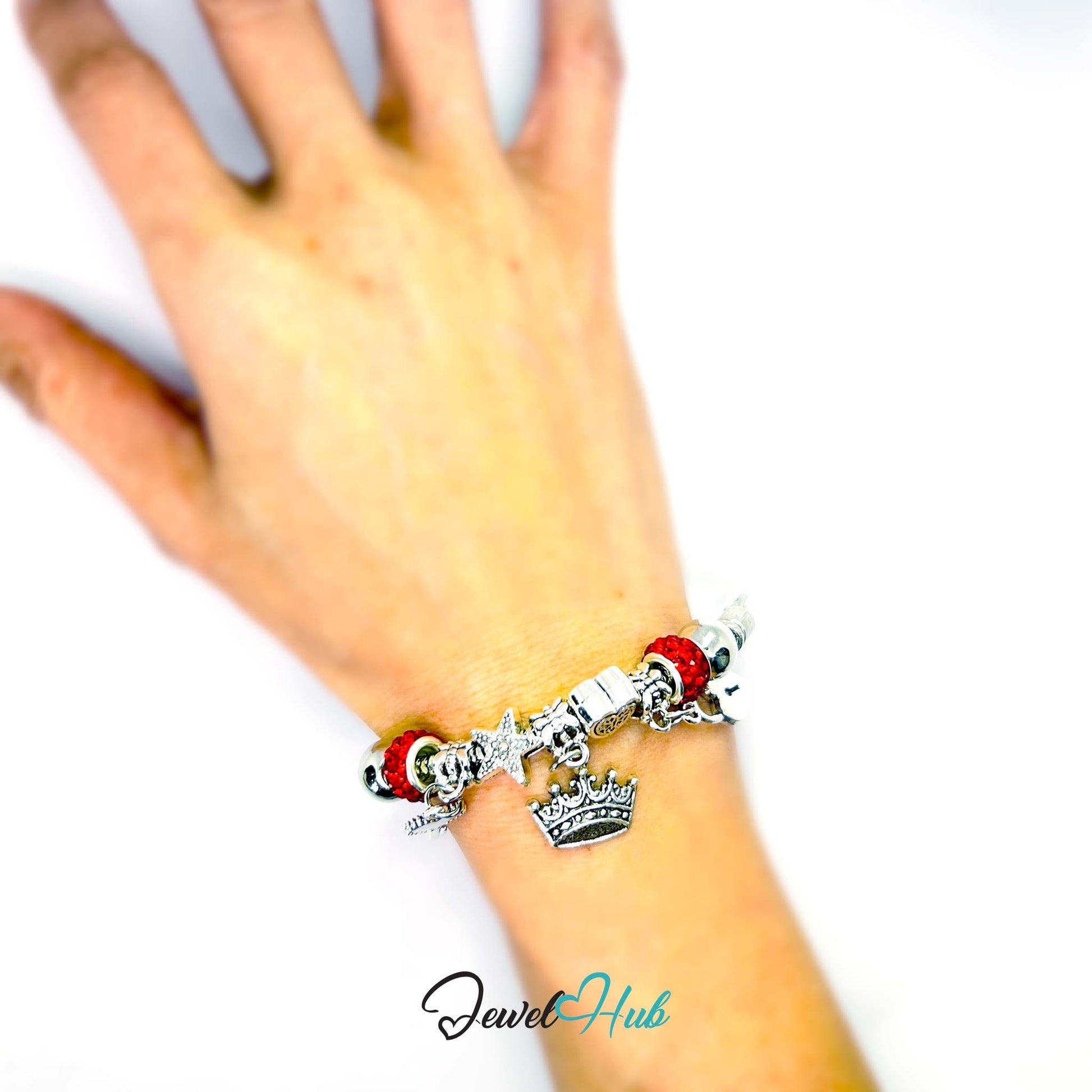 Bracelet with charms on a wrist against a white background, featuring the brand 'Jewel Hub'.
