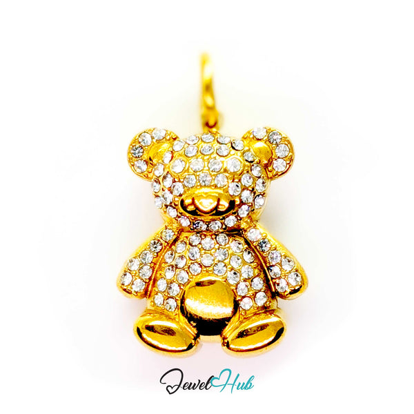 A gold teddy bear pendant encrusted with clear rhinestones, shown against a plain white background with a 'JewelHub' watermark at the bottom.