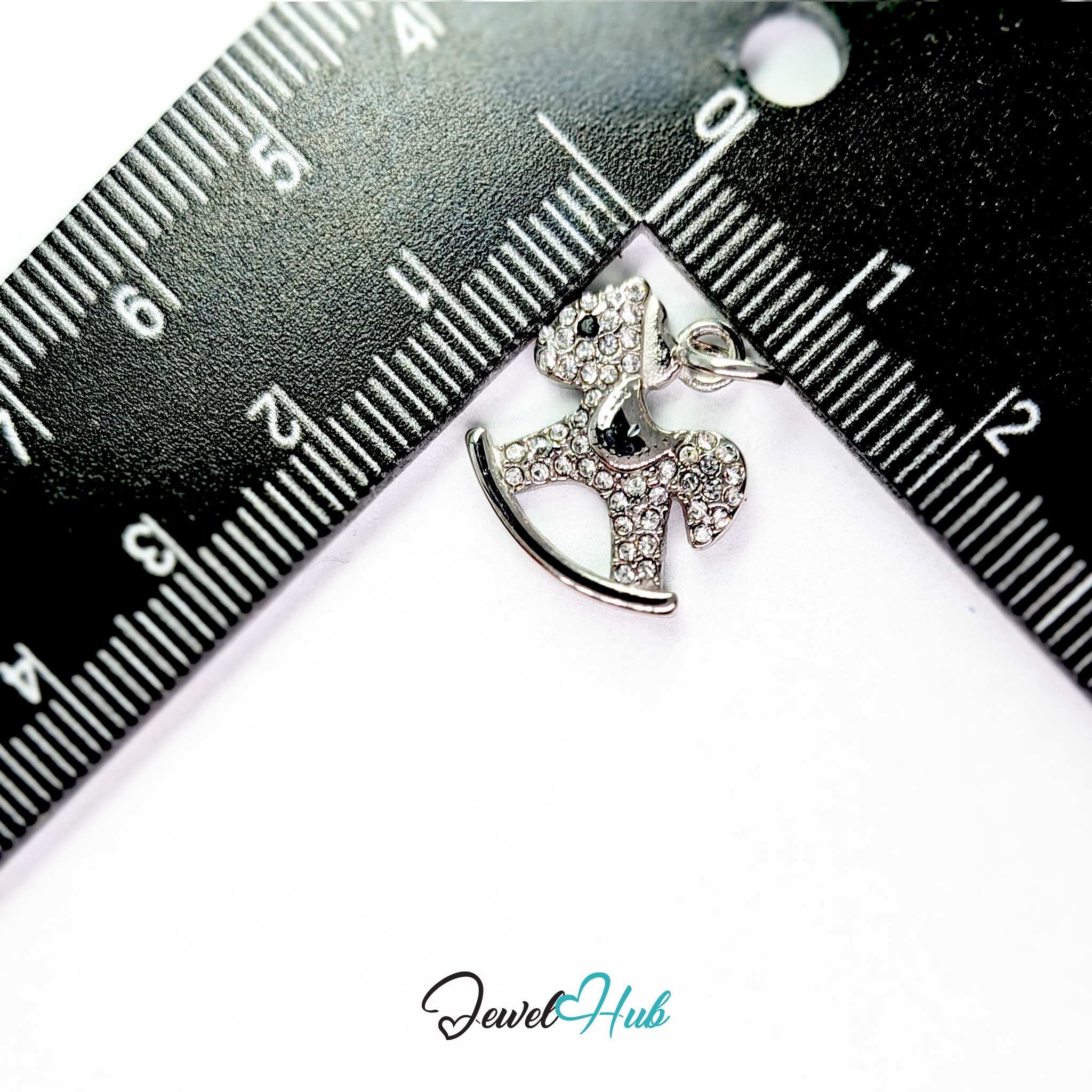 Silver rocking horse charm measured against a ruler at 15.5mm wide by 16.5mm tall - JewelHub