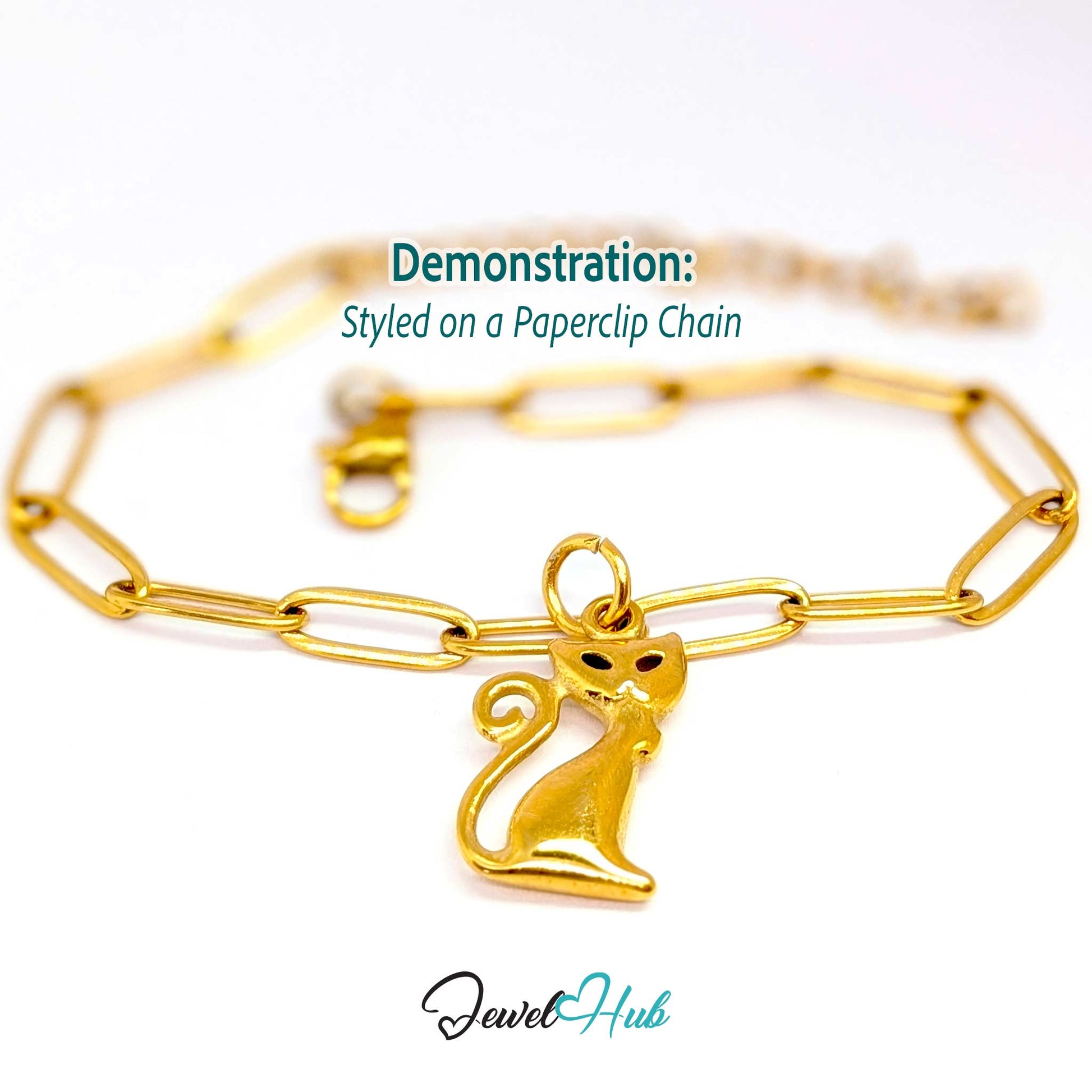 Gold standing cat charm styled on a gold paperclip chain bracelet - JewelHub