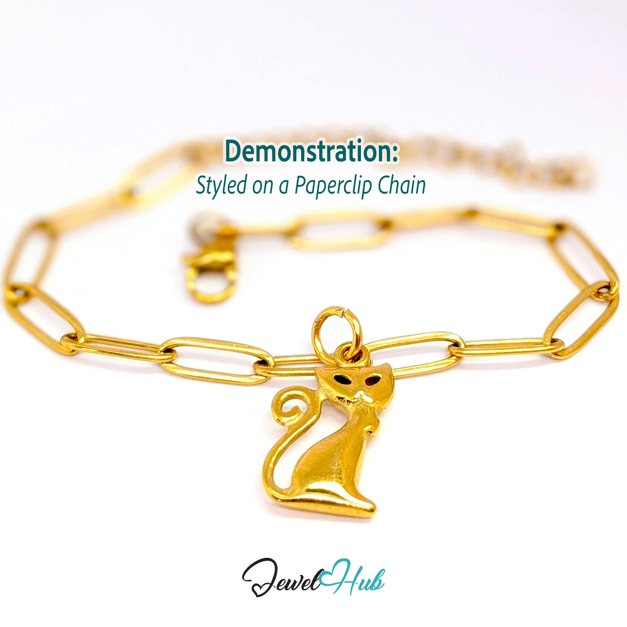 Gold standing cat charm styled on a gold paperclip chain bracelet - JewelHub