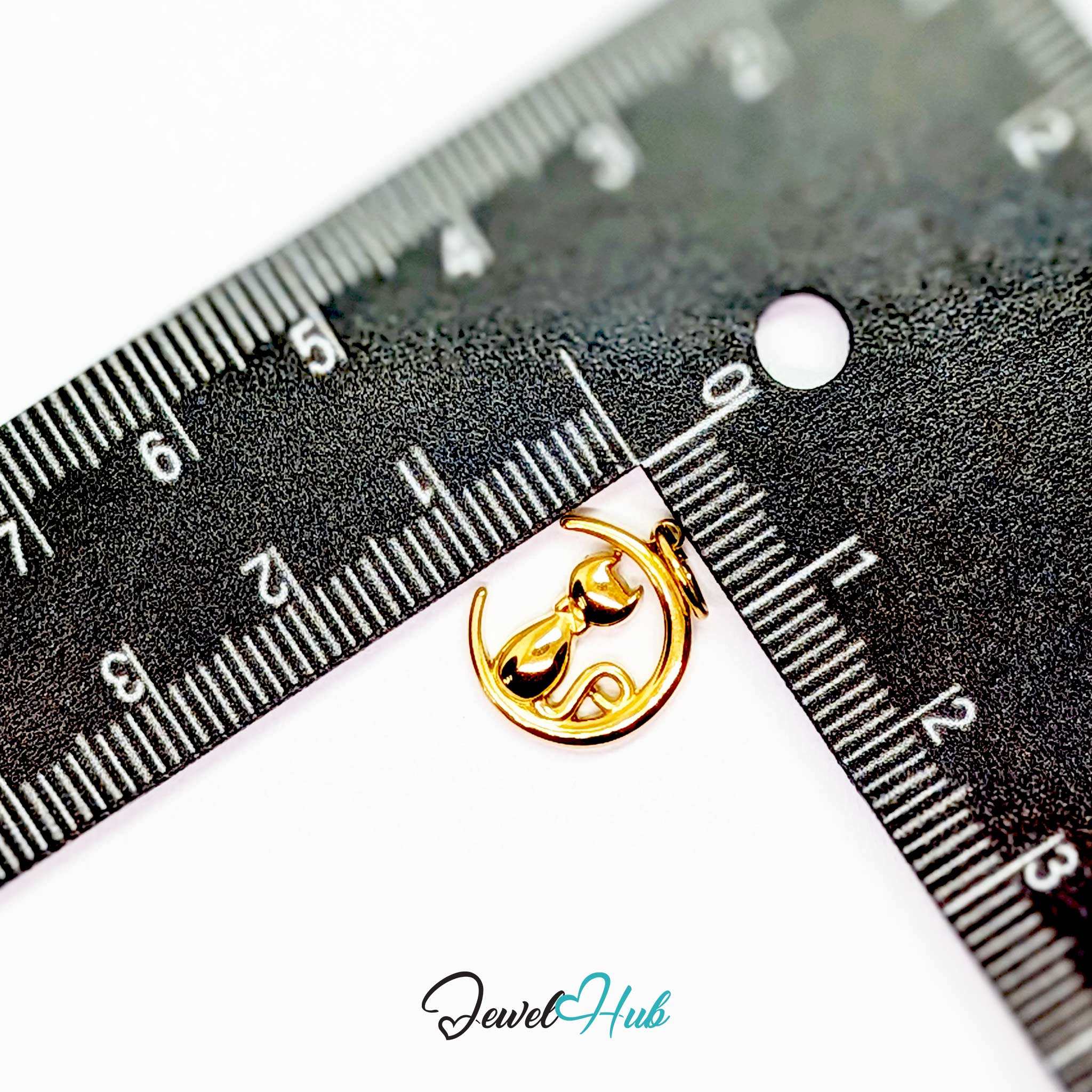 Gold cat and moon charm measured against a ruler at 12.5mm wide by 15mm tall - JewelHub