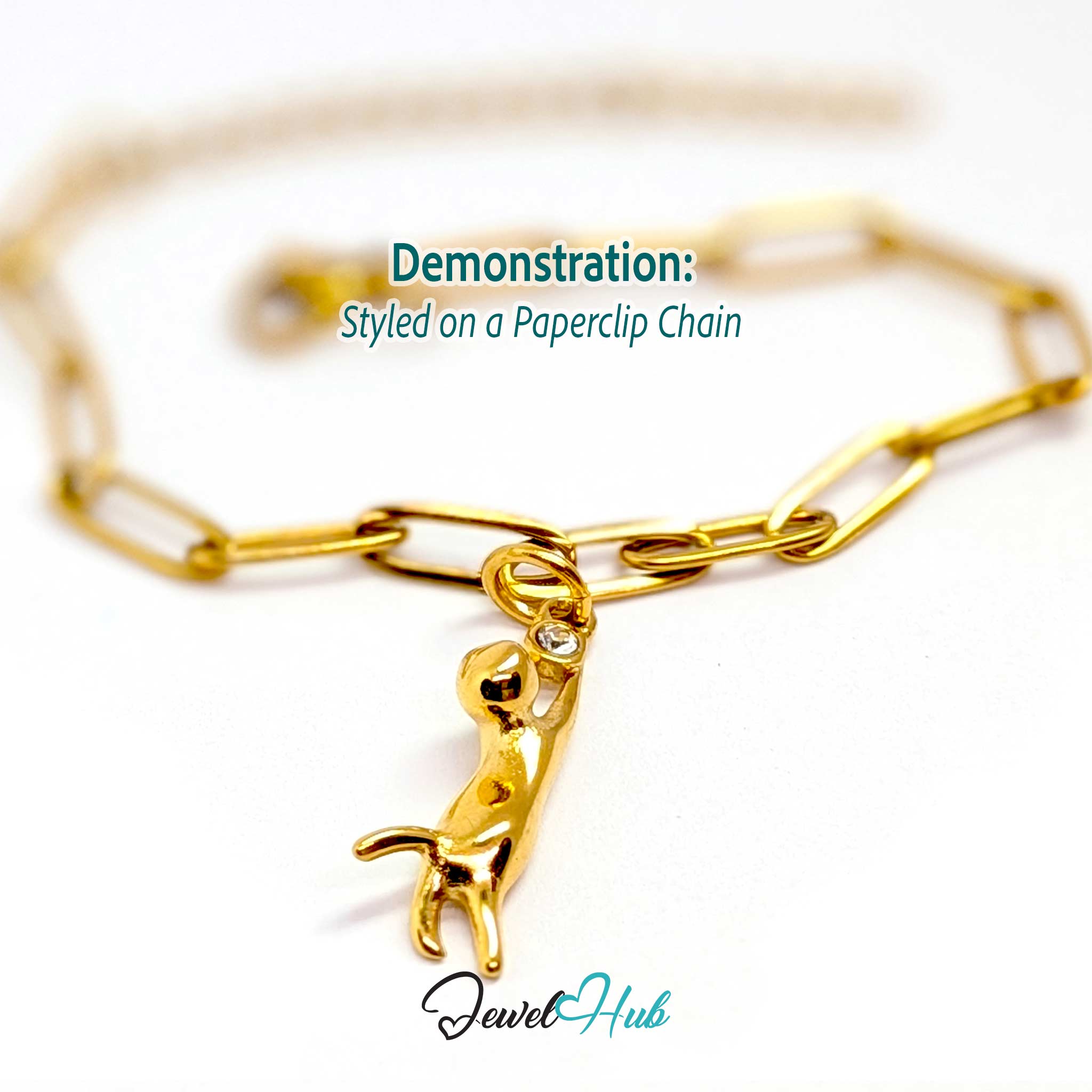 Gold hanging cat charm styled on a gold paperclip chain bracelet - JewelHub