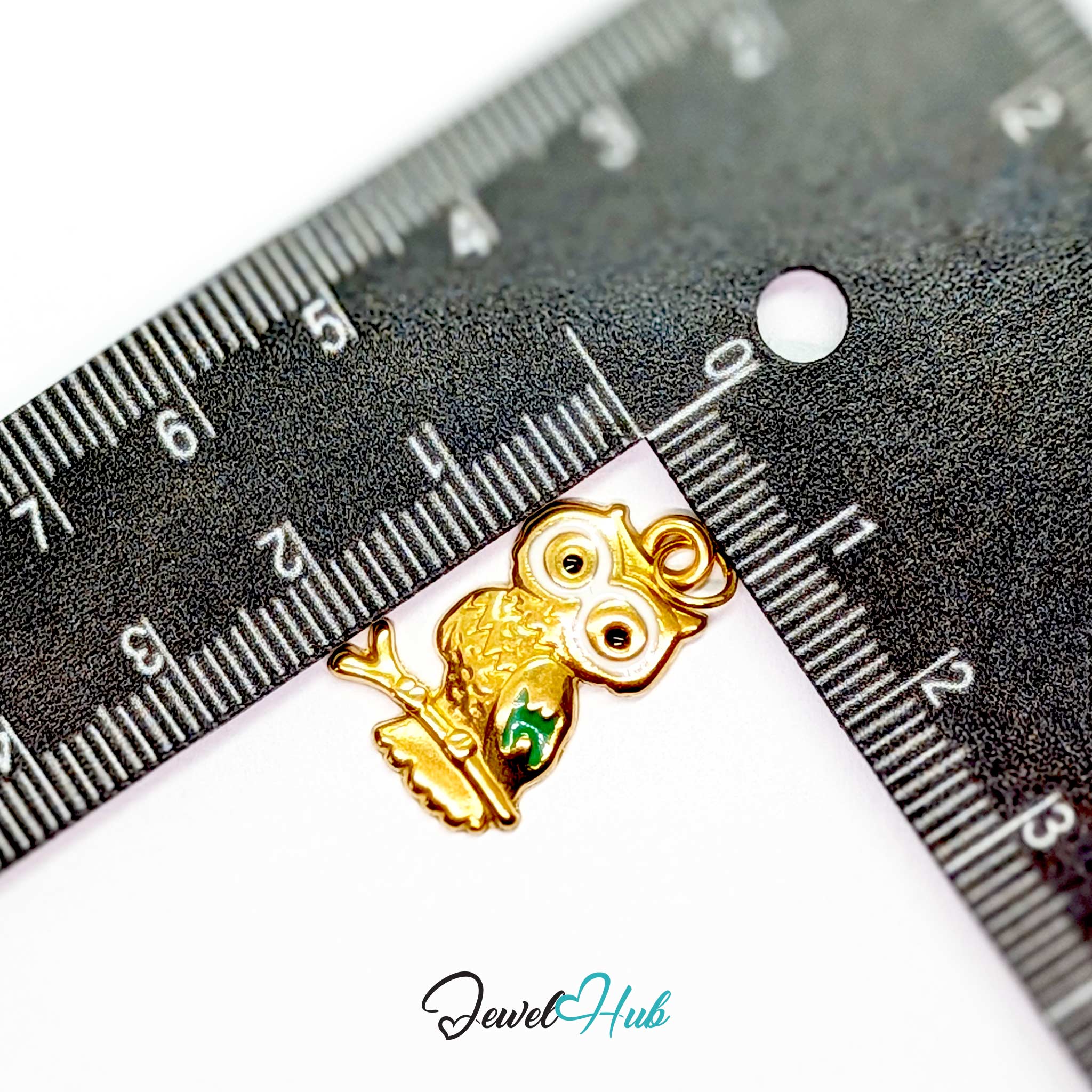 Gold owl charm measured against a ruler at 14mm wide by 23mm tall - JewelHub