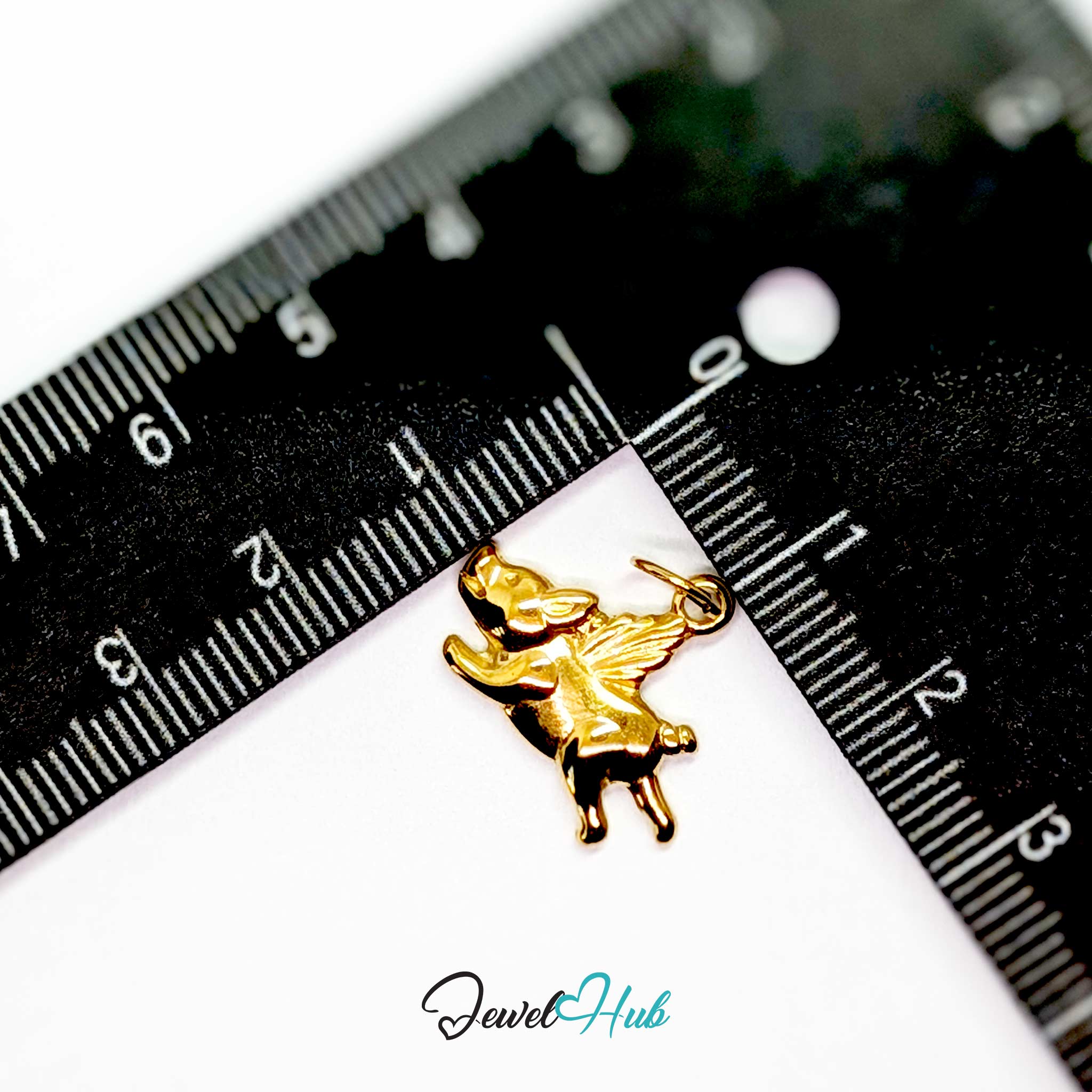 Gold flying pig charm measured against a ruler at 17mm wide by 16mm tall - JewelHub