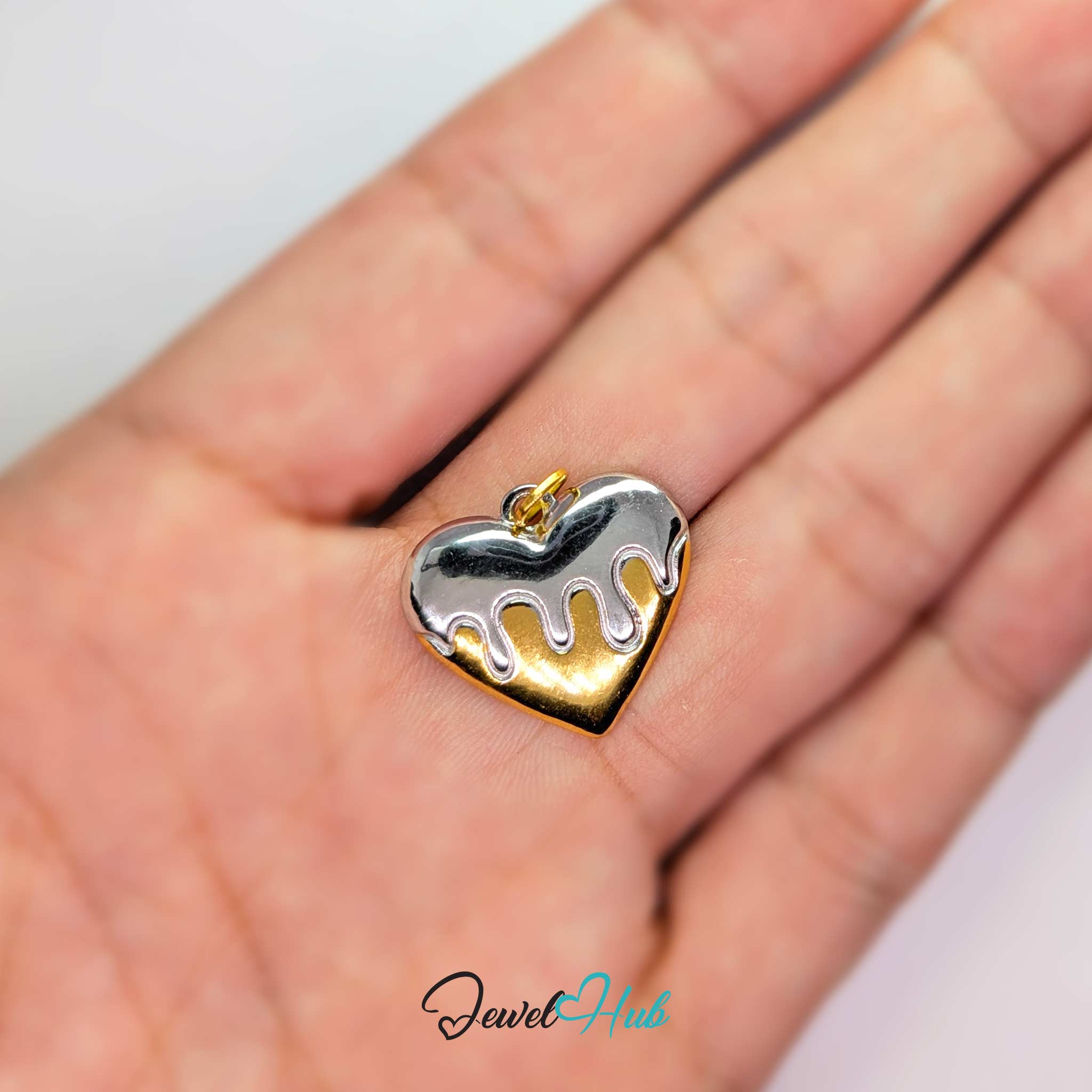 Drip Heart charm, two-tone stainless steel, held in the hand to show its size - JewelHub