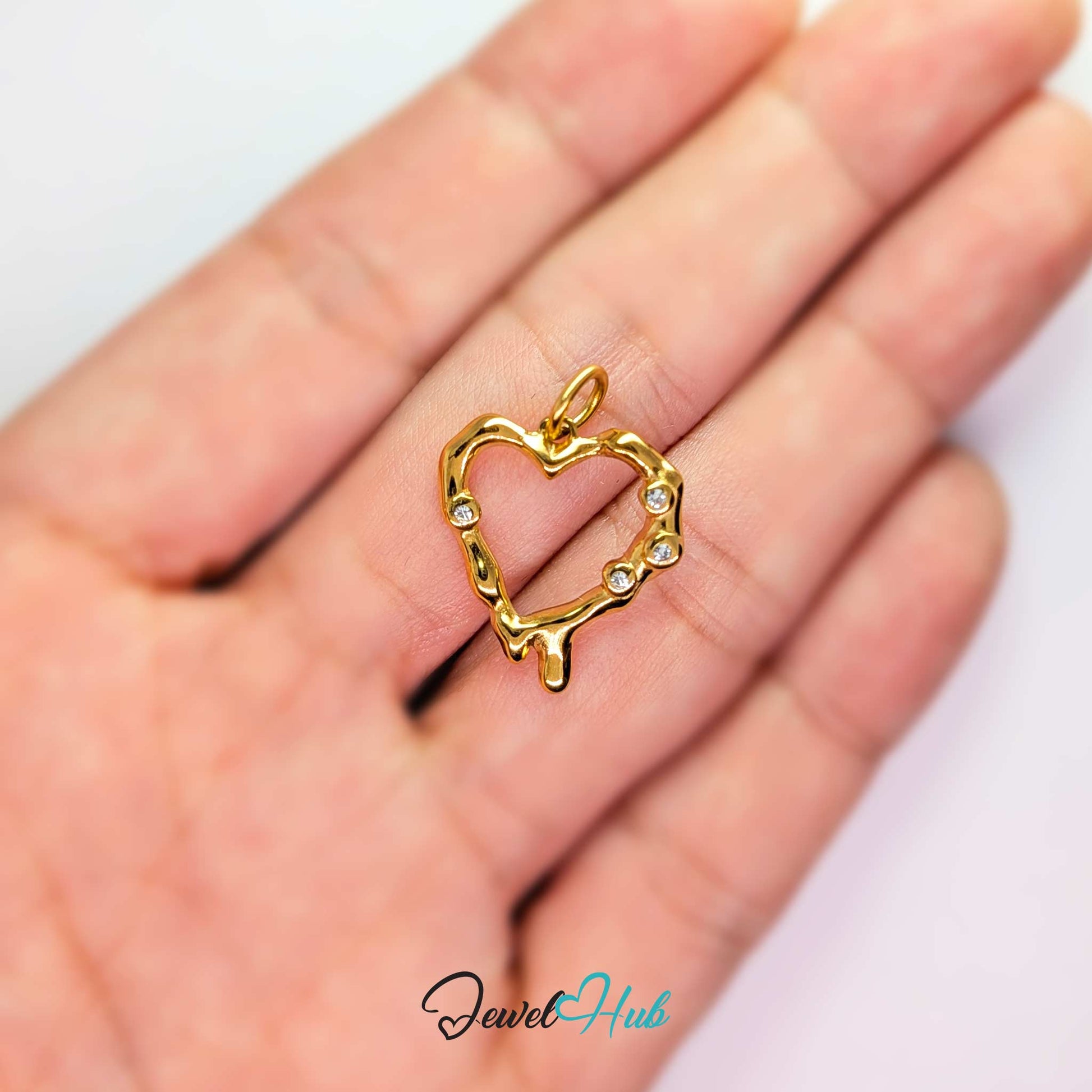 Outline Heart charm, gold stainless steel, held in the hand to show its size - JewelHub