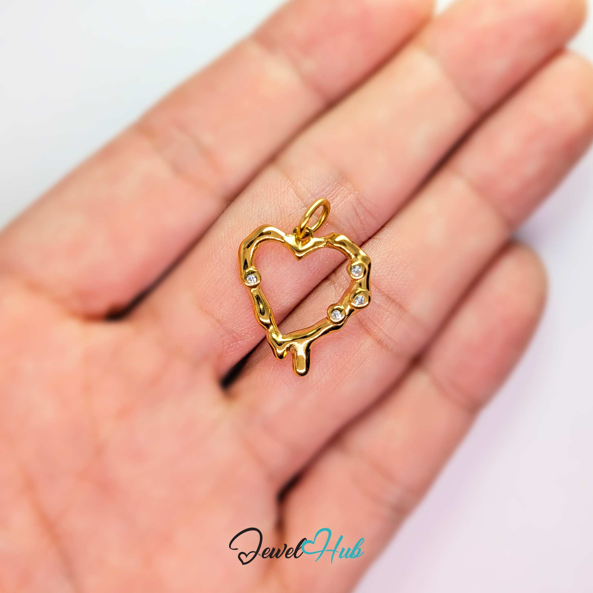 Outline Heart charm, gold stainless steel, held in the hand to show its size - JewelHub