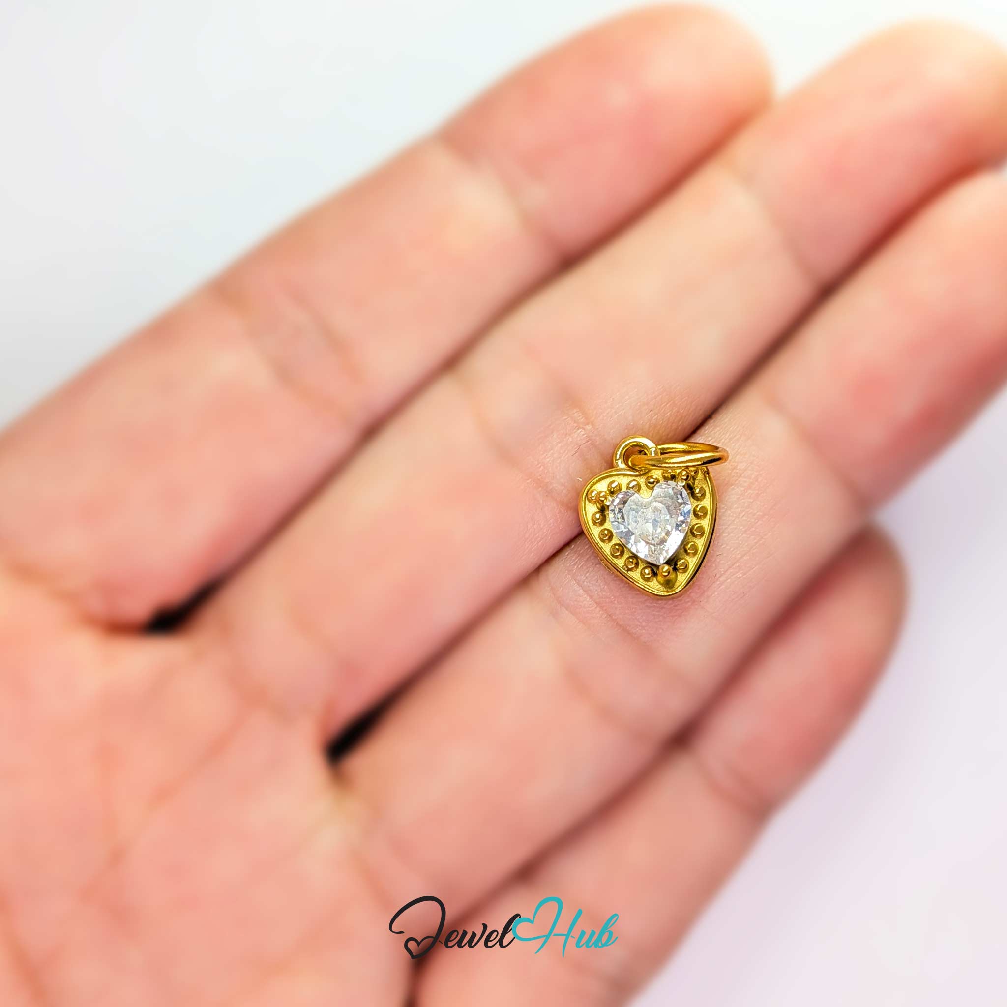 Gem Heart charm, gold stainless steel, held in the hand to show its size - JewelHub
