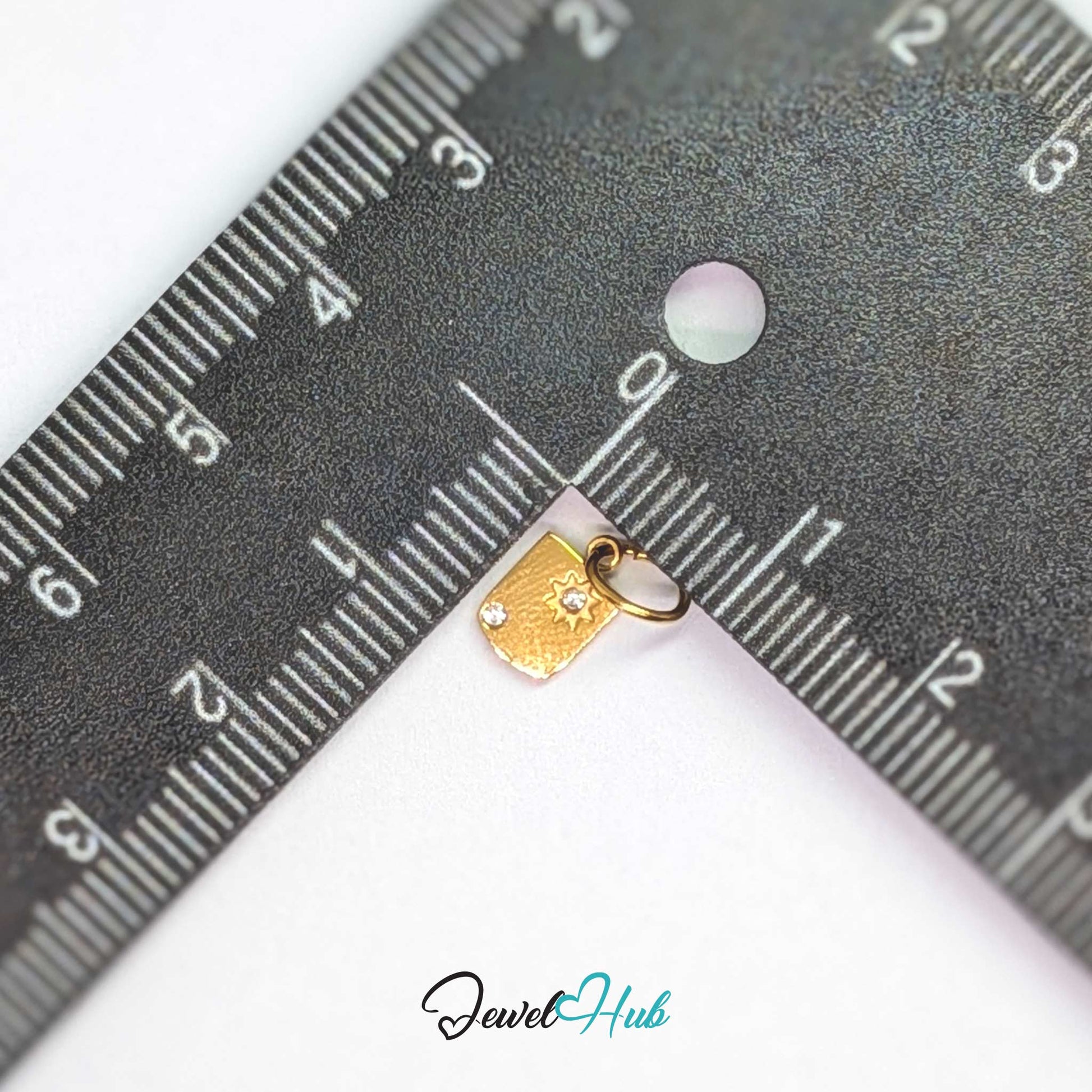 Mini Star Shield charm, gold stainless steel, measured against a ruler at 5.6 x 8.5mm - JewelHub