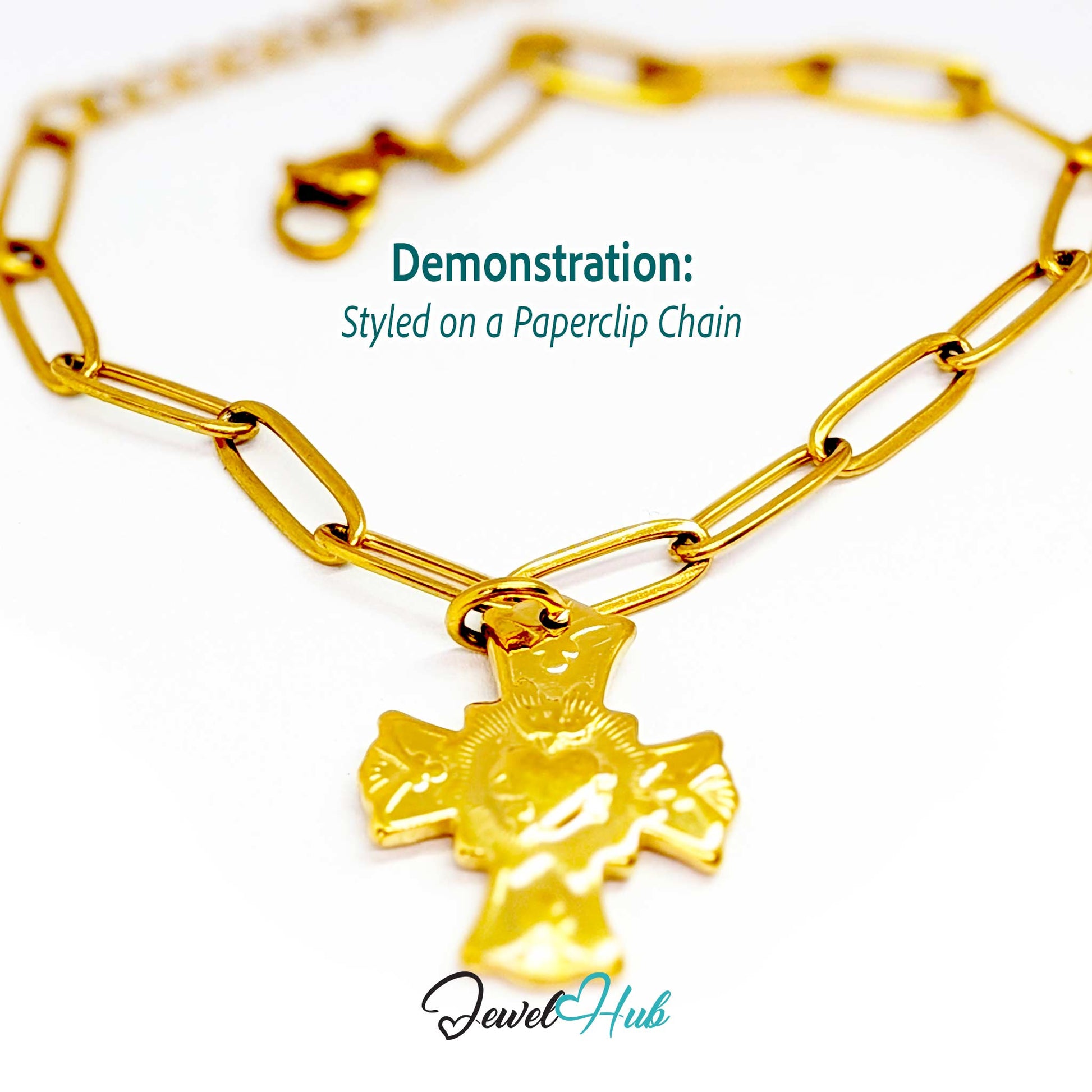Dove cross charm in gold stainless steel with a radiant heart - styled on a gold paperclip chain bracelet - JewelHub