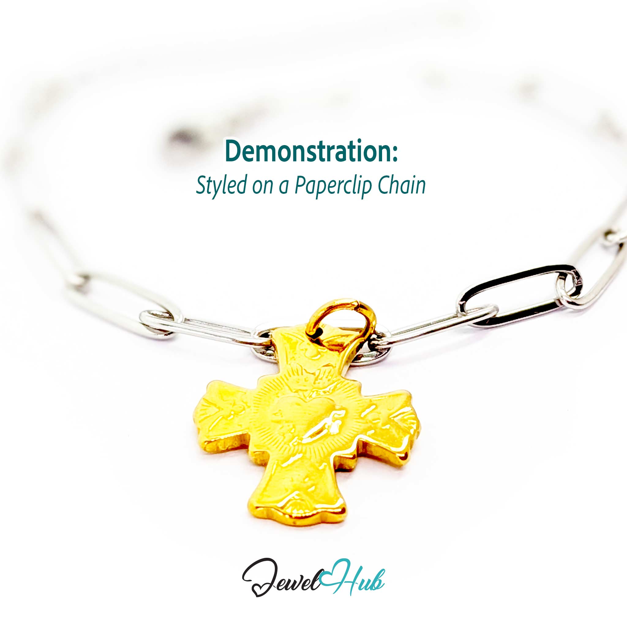 Dove cross charm in gold stainless steel with a radiant heart - styled on a silver paperclip chain bracelet - JewelHub