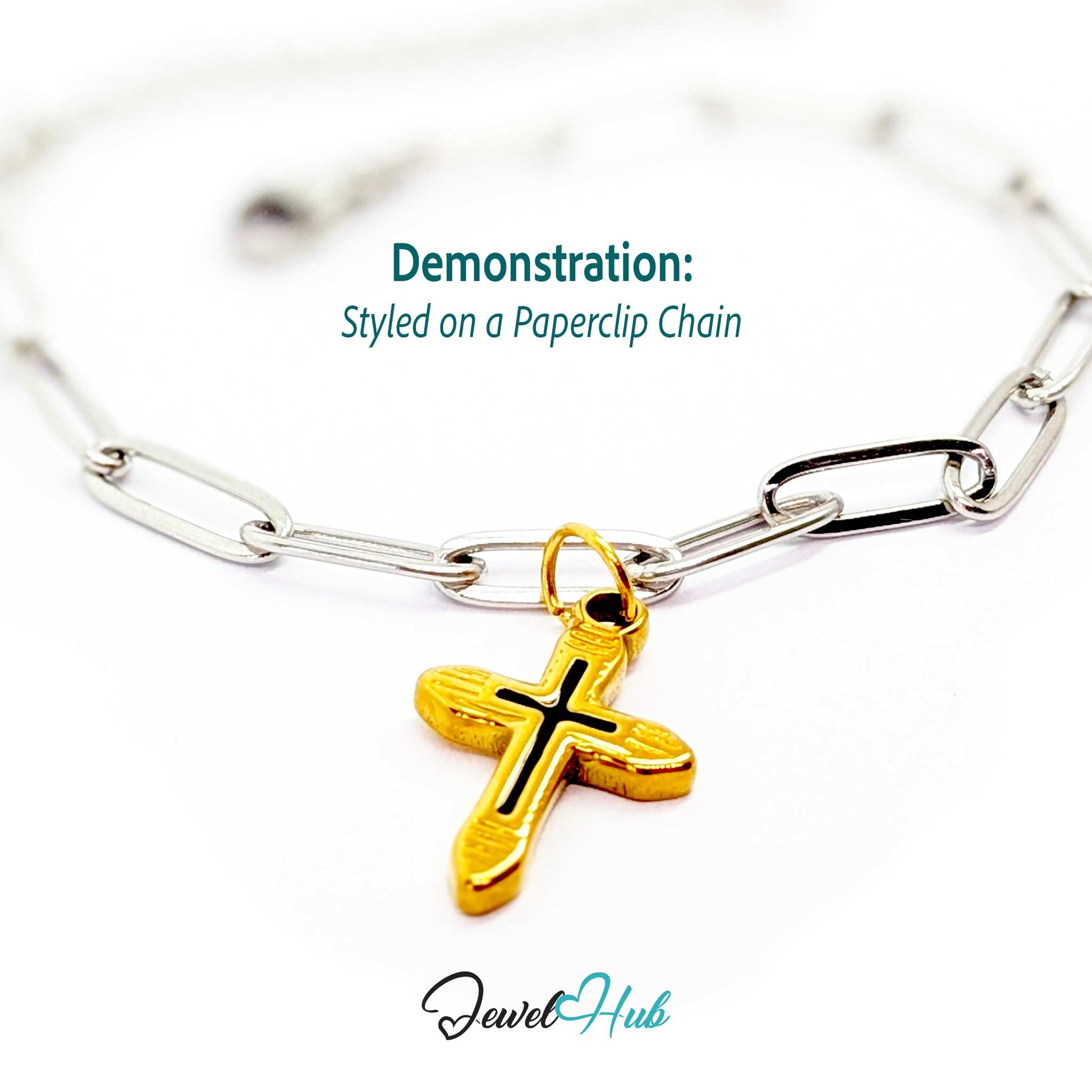 Cross charm in gold stainless steel with a black enamel inlay - styled on a silver paperclip chain bracelet - JewelHub