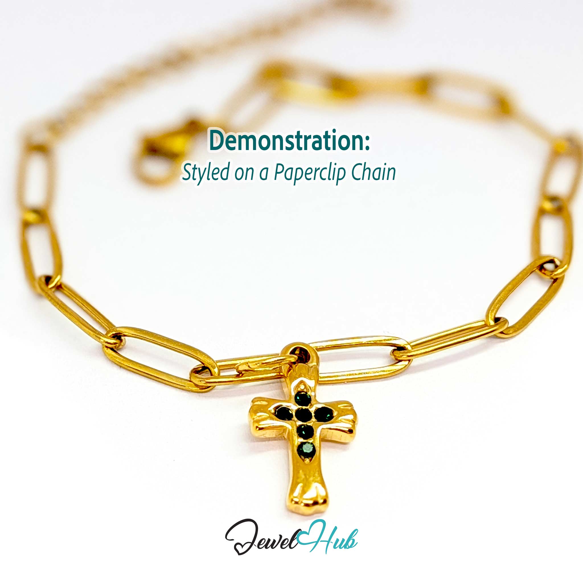 Small cross charm in gold stainless steel with six green stones - styled on a gold paperclip chain bracelet - JewelHub
