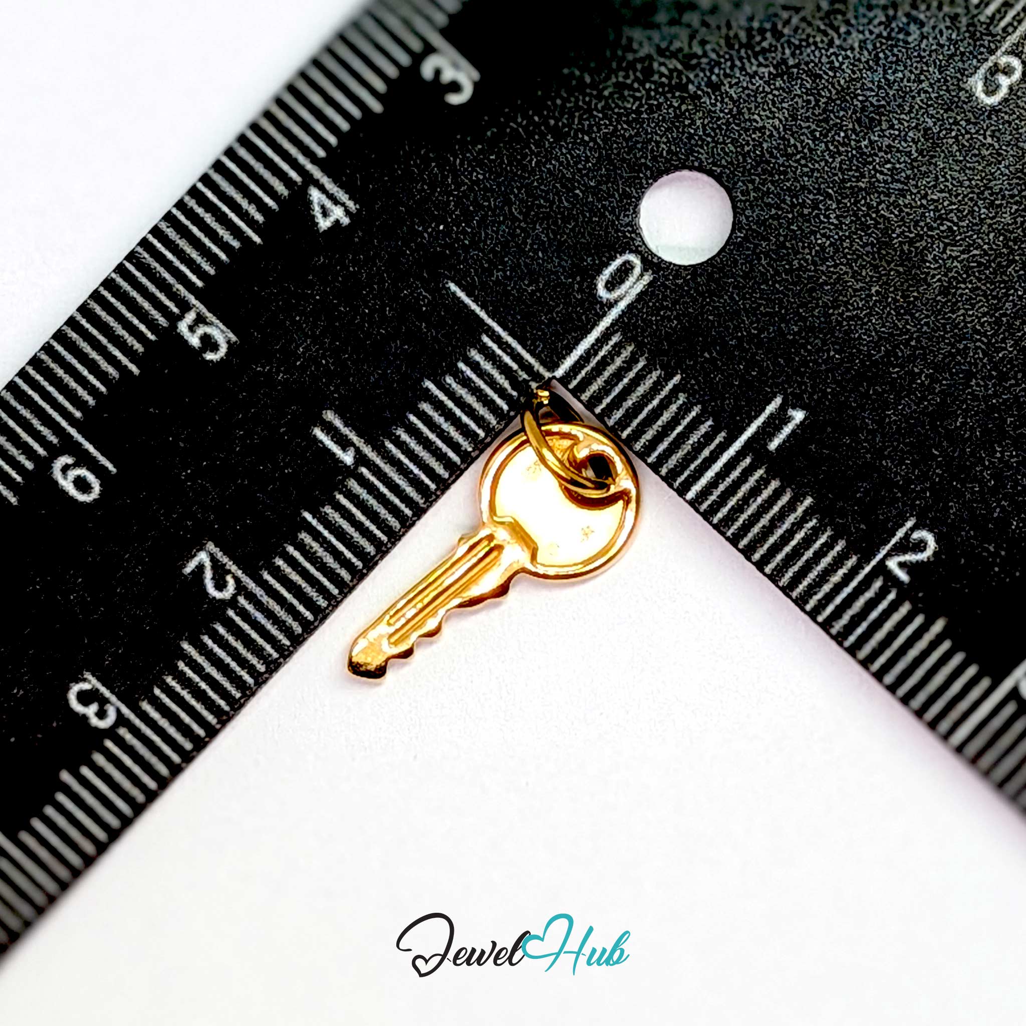 Everyday key charm in gold stainless steel with a plain round head - beside a ruler for scale - JewelHub