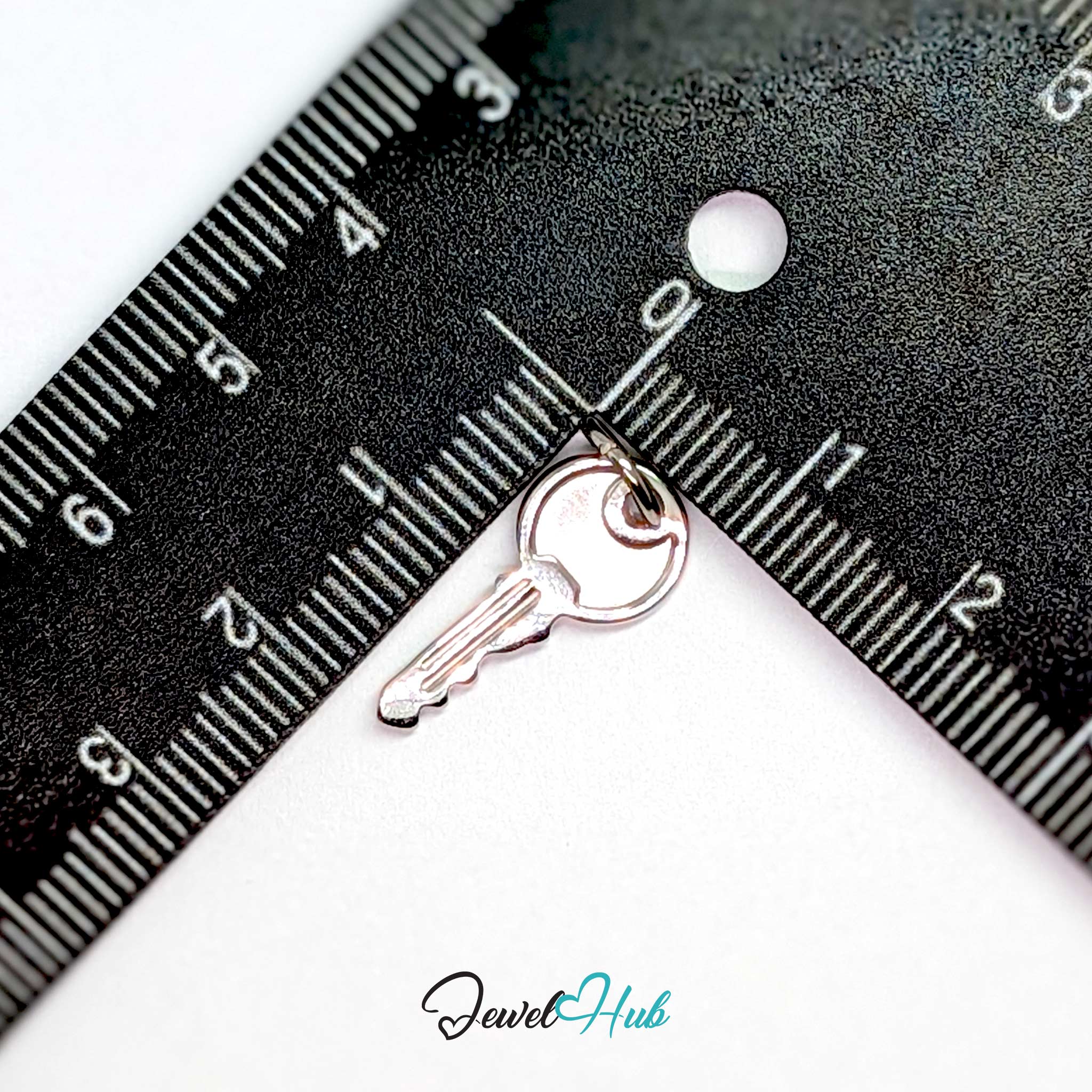 Everyday key charm in silver stainless steel with a plain round head - beside a ruler for scale - JewelHub