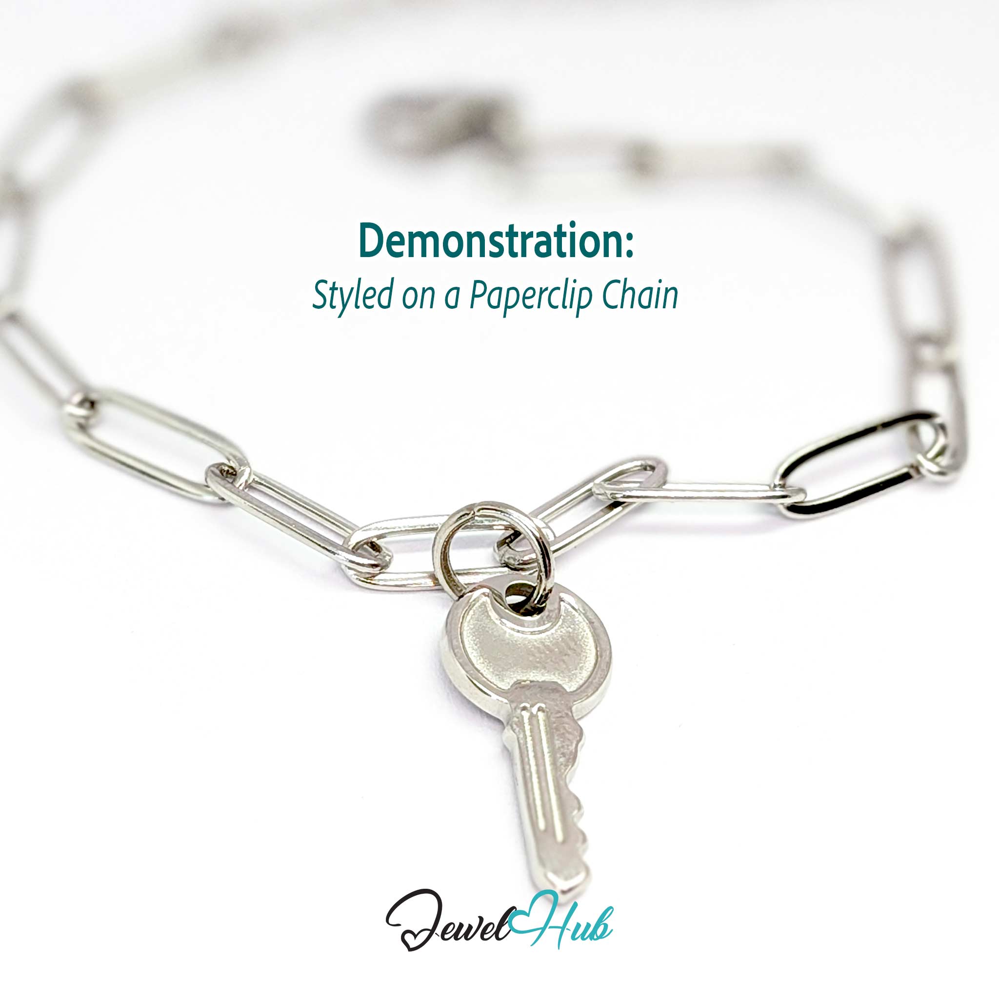 Everyday key charm in silver stainless steel with a plain round head - styled on a silver paperclip chain bracelet - JewelHub